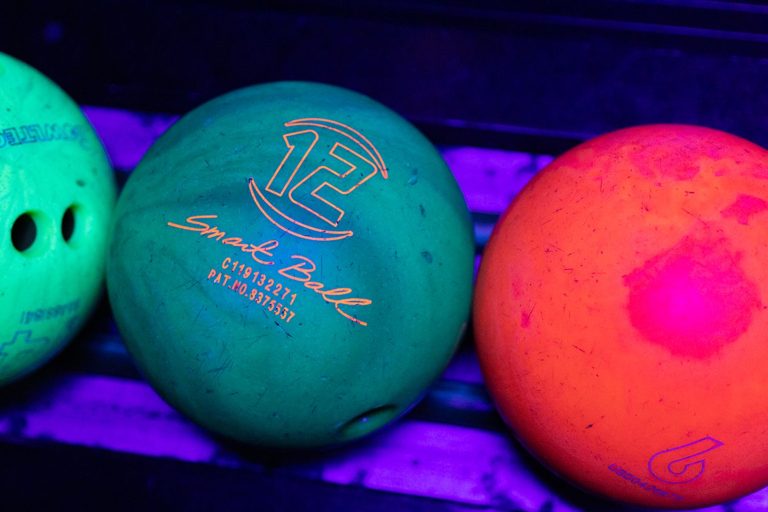 Three glowing bowling balls under black light, featuring a teal Storm ball with number 12, orange, and green balls.
Yip's Hengelo - Branding