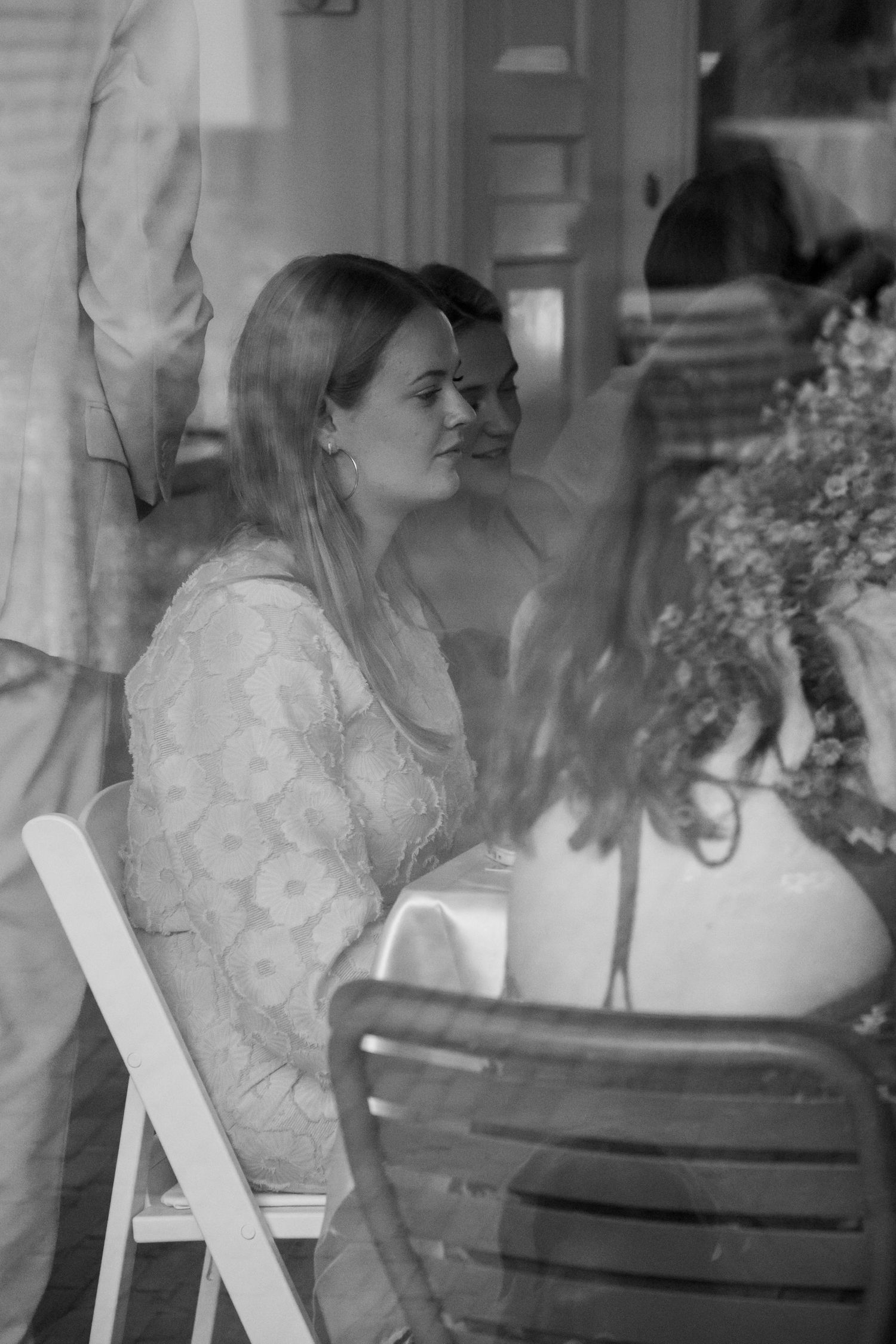 Black and white photo of smiling women at an elegant indoor dining event through a window.
Evelijn - 21 Diner - Event shoot
