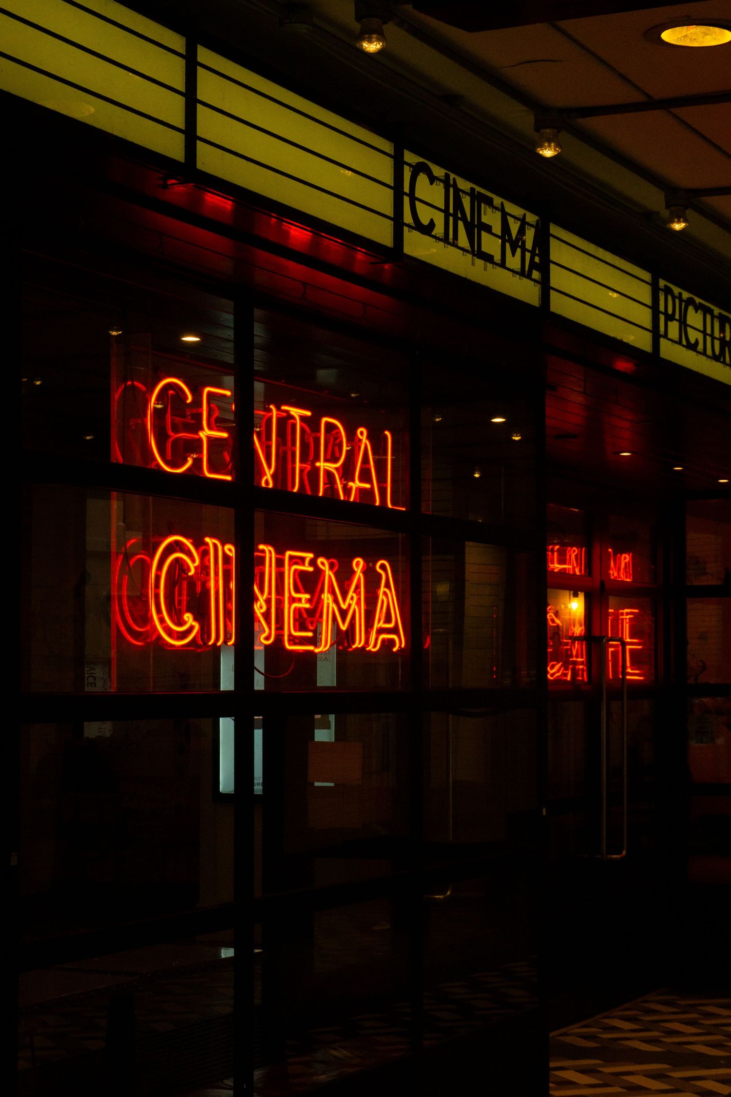 Red neon sign reading Central Cinema glows on a dark building facade at night.
Reizen - Lynn - Londen