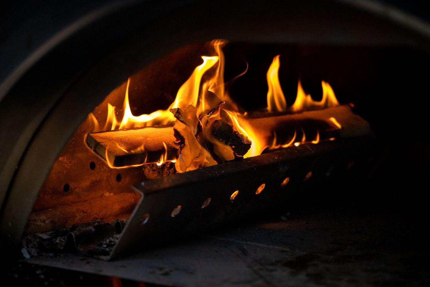 Burning wood fire inside a pizza oven with bright orange flames.
Evelijn - 21 Diner - Event shoot