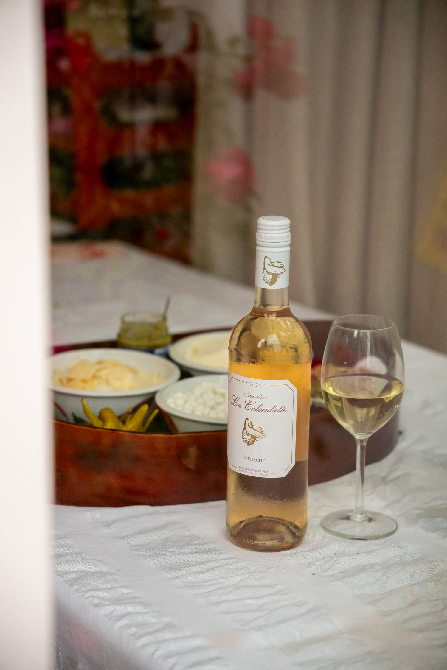 Bottle of La Colombette white wine beside a glass on a table with dips.
Evelijn - 21 Diner - Event shoot