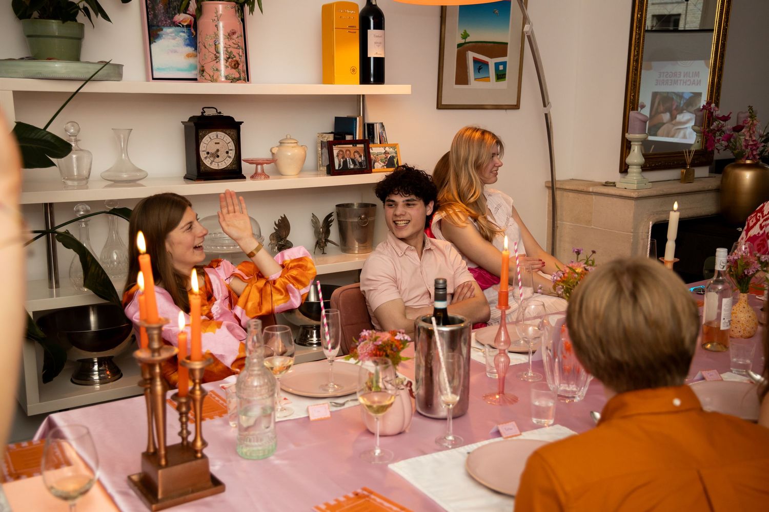 Friends laughing and enjoying dinner party with pink table setting and candlelight.
Evelijn - 21 Diner - Event shoot