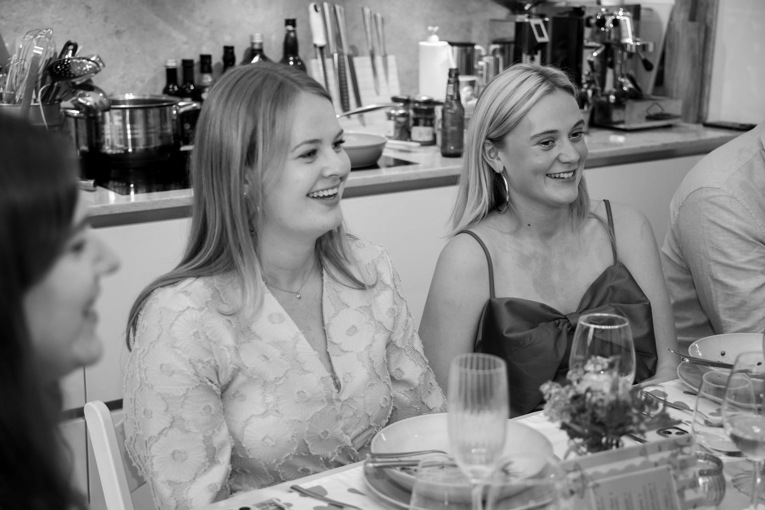 Two women laughing and smiling at a dinner table in a black and white photo.
Evelijn - 21 Diner - Event shoot