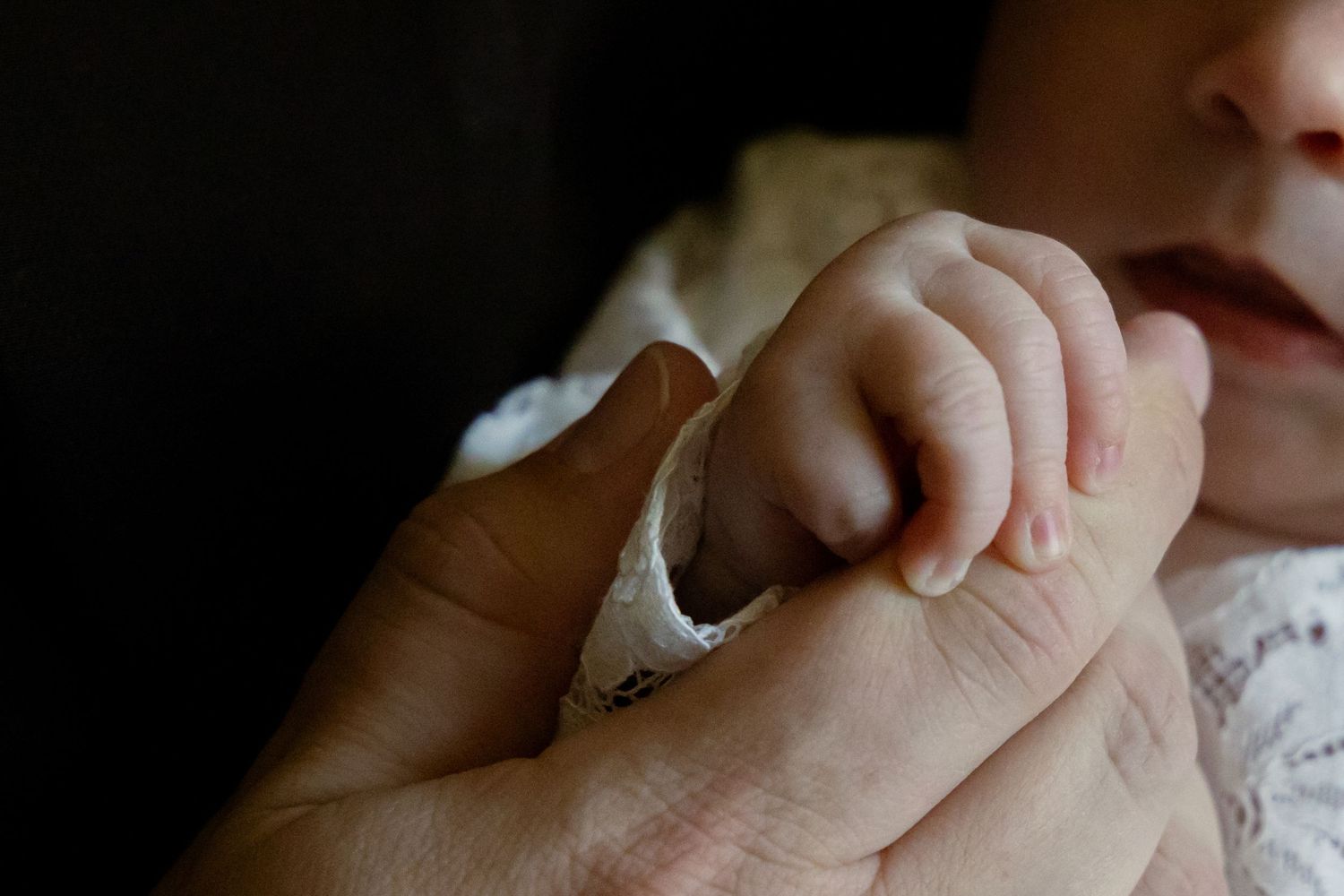 Newborn baby hand gently gripping adult finger wearing ring.
Ellis - Newborn shoot