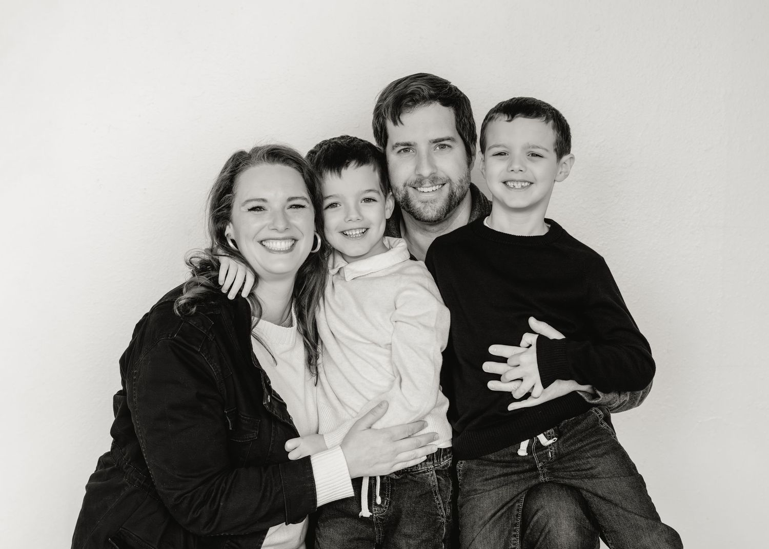 Black and white photo collage showing a happy family with parents and children posing together.