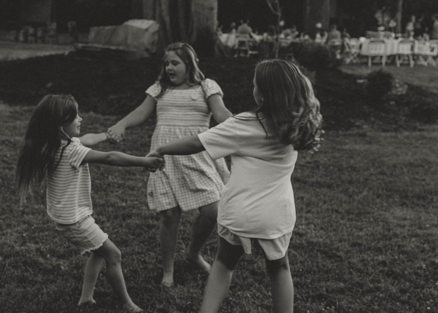 A black and white image of children playing ring-around-the-rosie in a field.Puyallup Family Photographer, Puyallup Milestone Photography,,