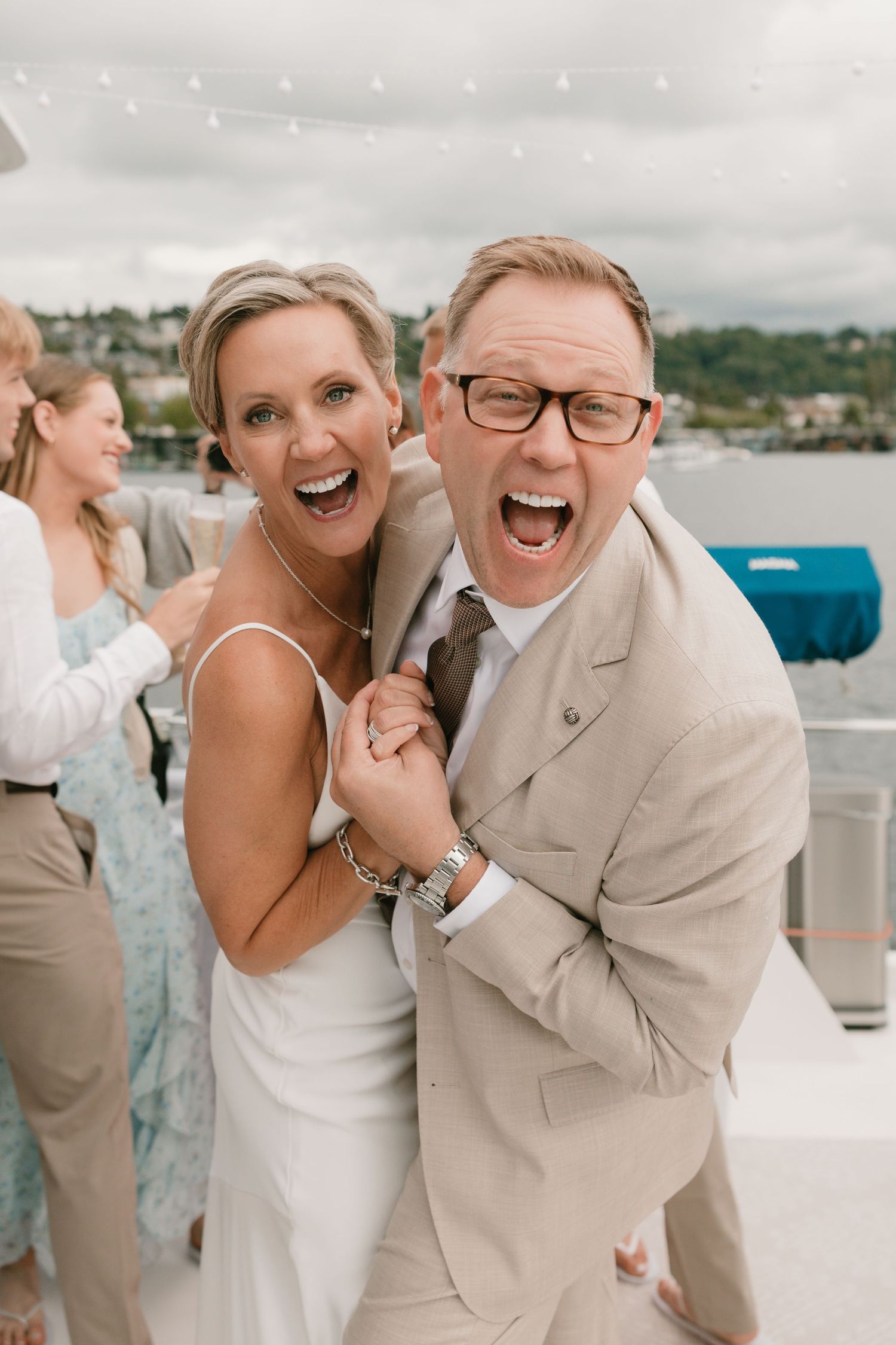 A joyful wedding moment captured in a series of candid photos showing laughter and happiness on a waterfront deck.