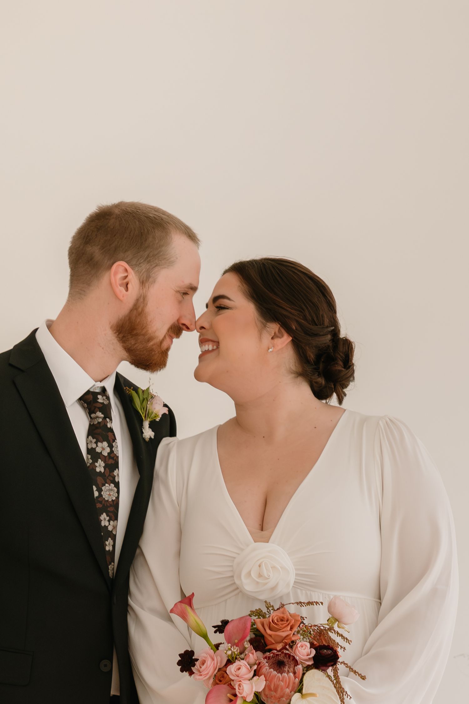 A romantic wedding couple shares intimate moments in a series of four candid photos with coral and pink floral bouquet details.