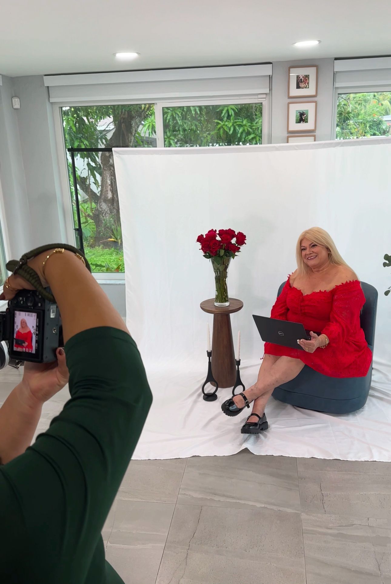 Behind the scenes photo of a photography session with red roses and white backdrop.
