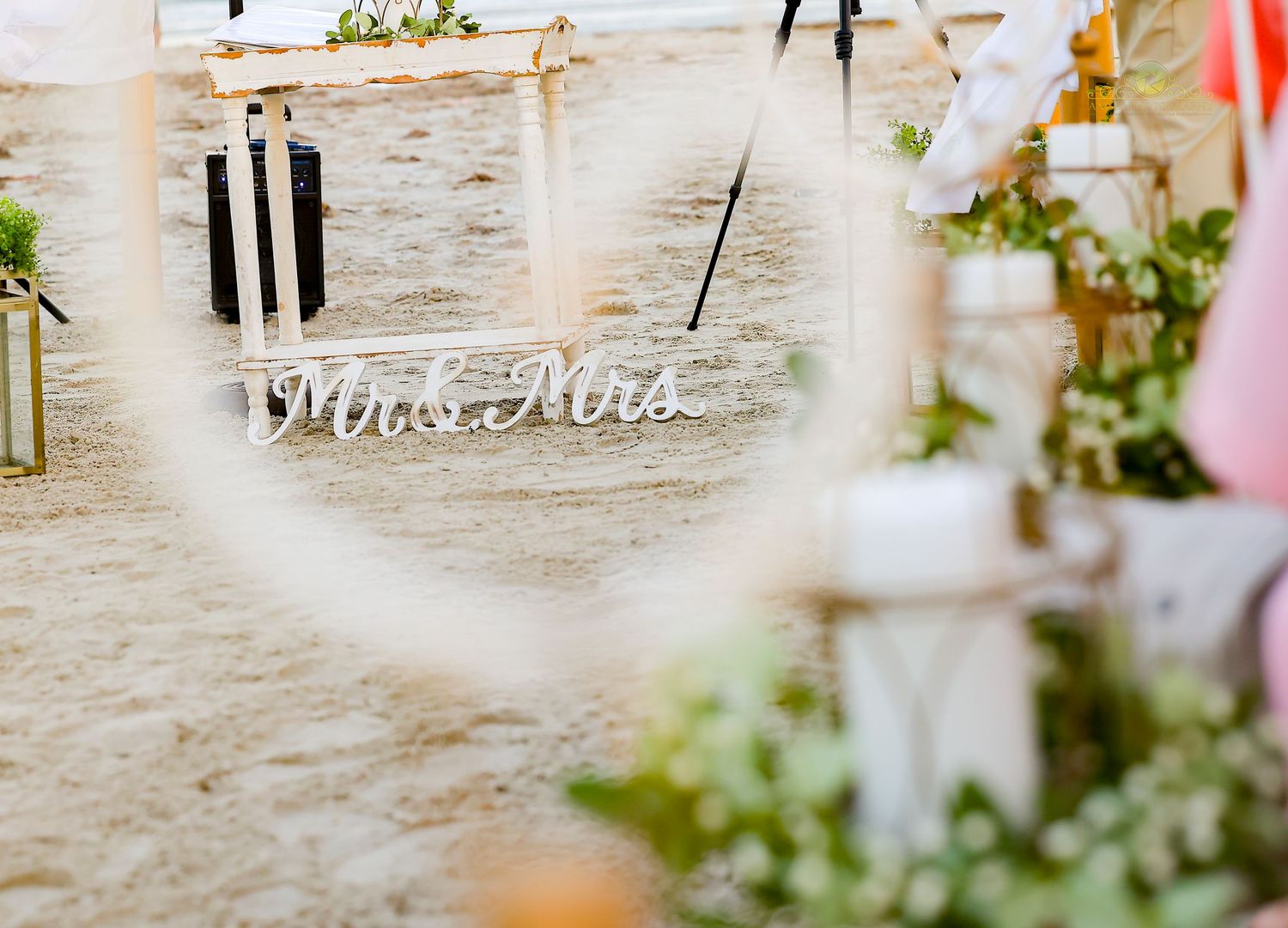 Delicate pink and white floral arrangements adorn a rustic stone wall at an elegant wedding reception.