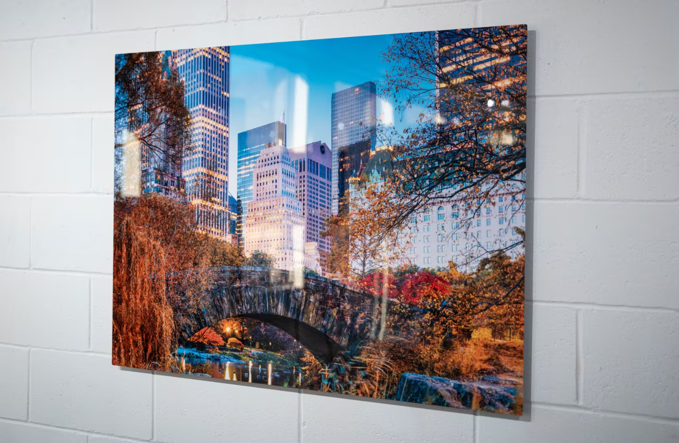 Three large canvas prints of New York City's Central Park in autumn displayed on a white wall.