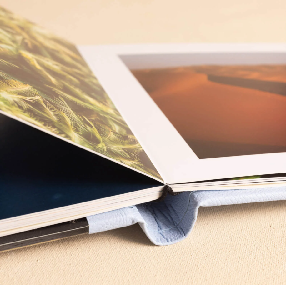 Close-up view of layered photo prints showing textural details and paper edges in warm lighting.