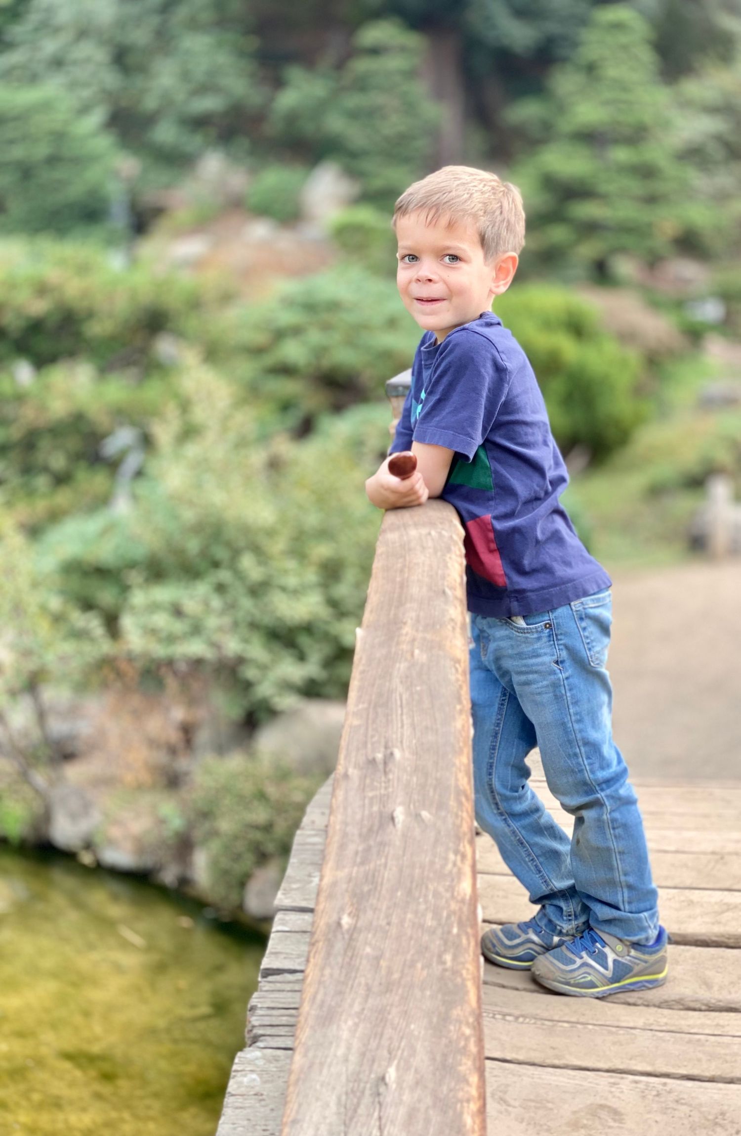 Young child poses for a photo while hiking at Hakone Gardens in Saratoga by Cindy Tucey Photography