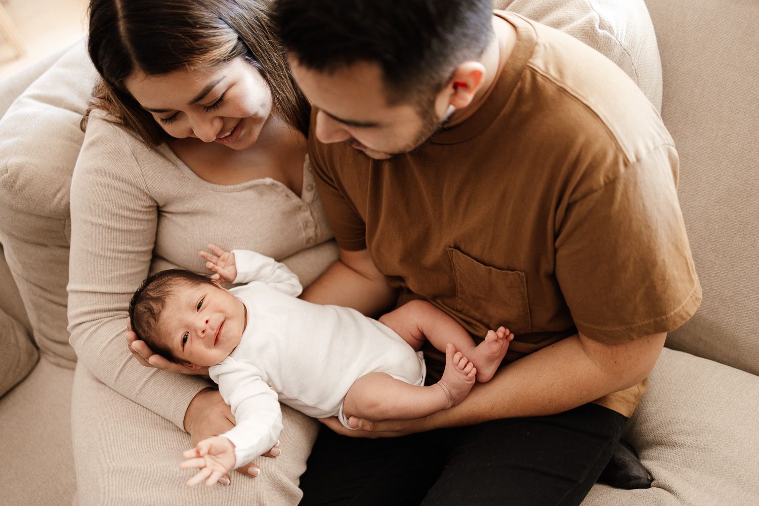 Newborn baby appears to smile and wave during in-home newborn photoshoot in San Jose with Bay Area Photographer