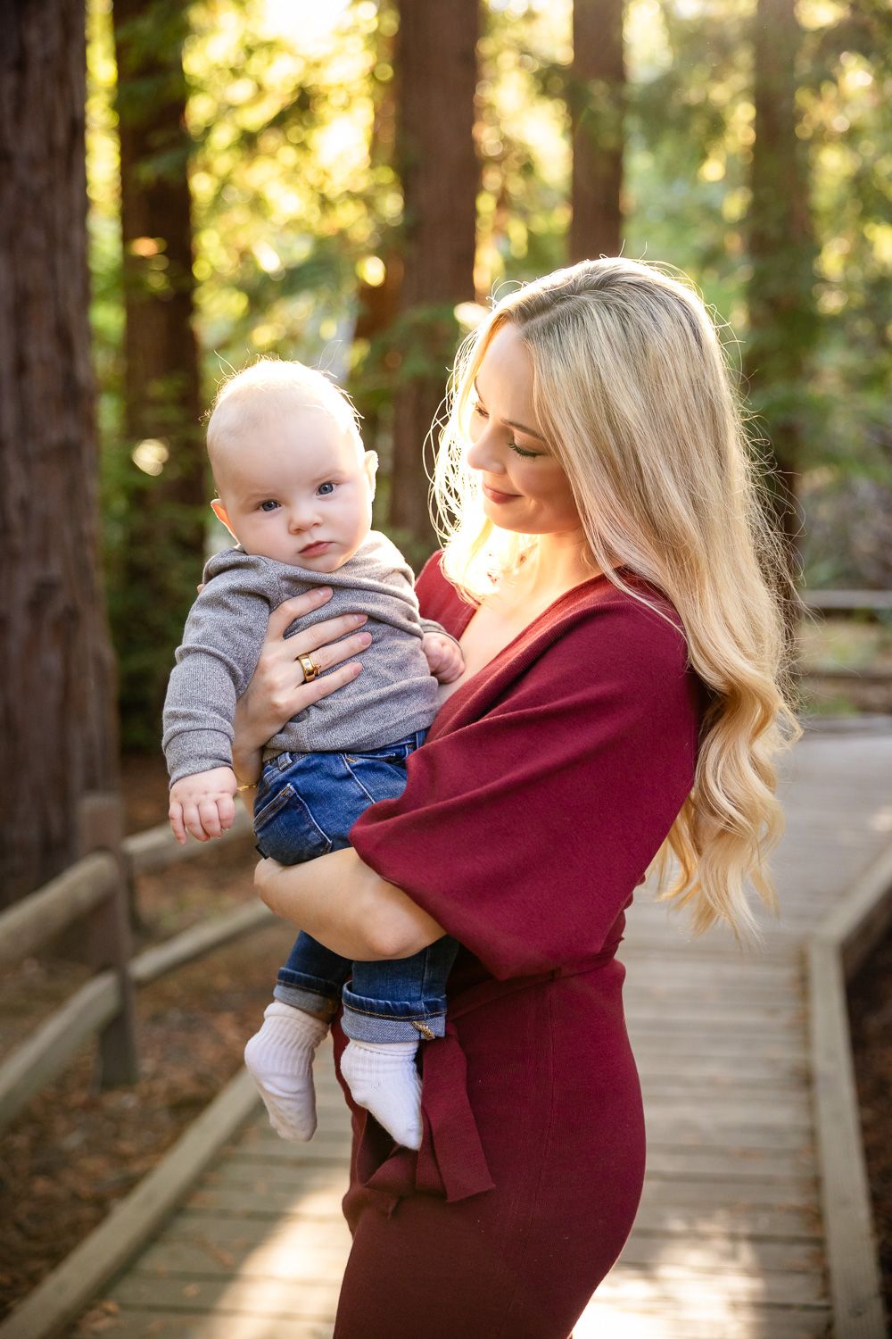A mom holds her baby in the redwood forest