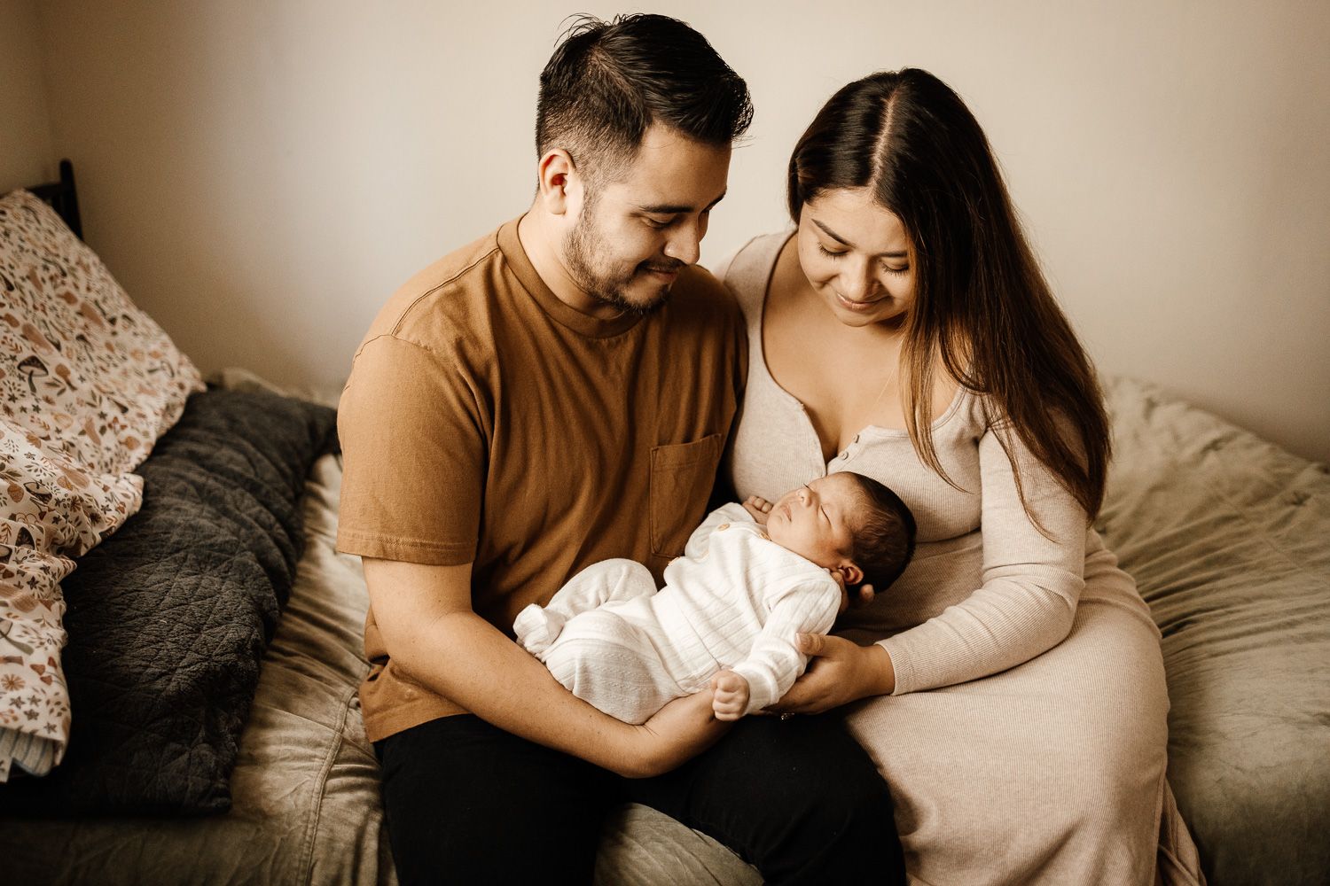 Parents gaze lovingly at their sleeping newborn at their baby photo session in their San Jose home with Bay Area Photographer Cindy Tucey