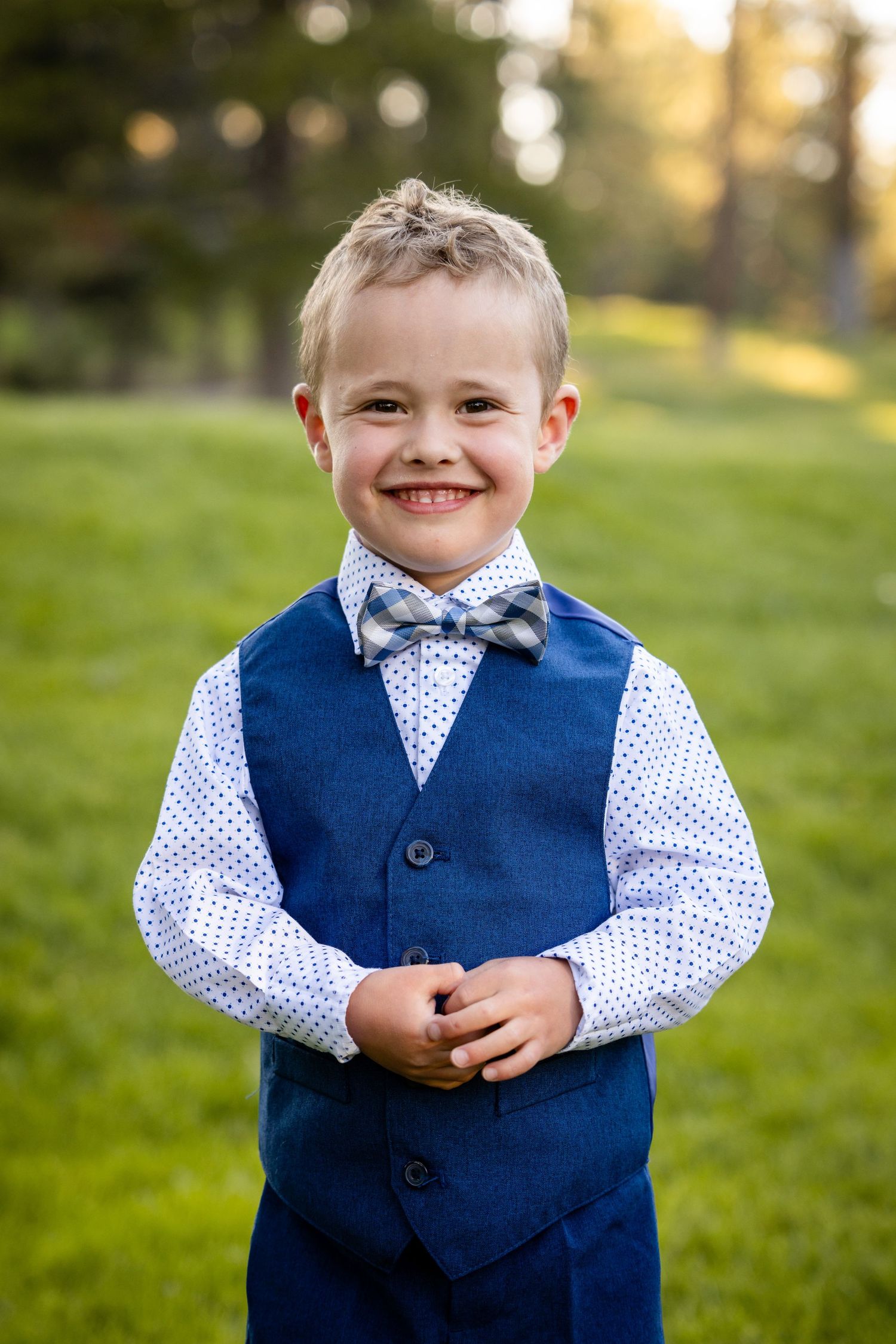 Young boy smiles while standing on grass in Tahoe Donner at golden hour