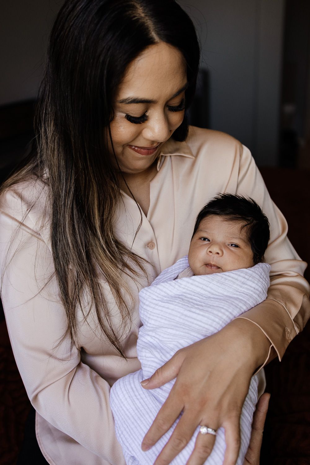 Mom holds newborn baby in at-home Truckee photo session with Truckee Newborn Photographer Cindy Tucey