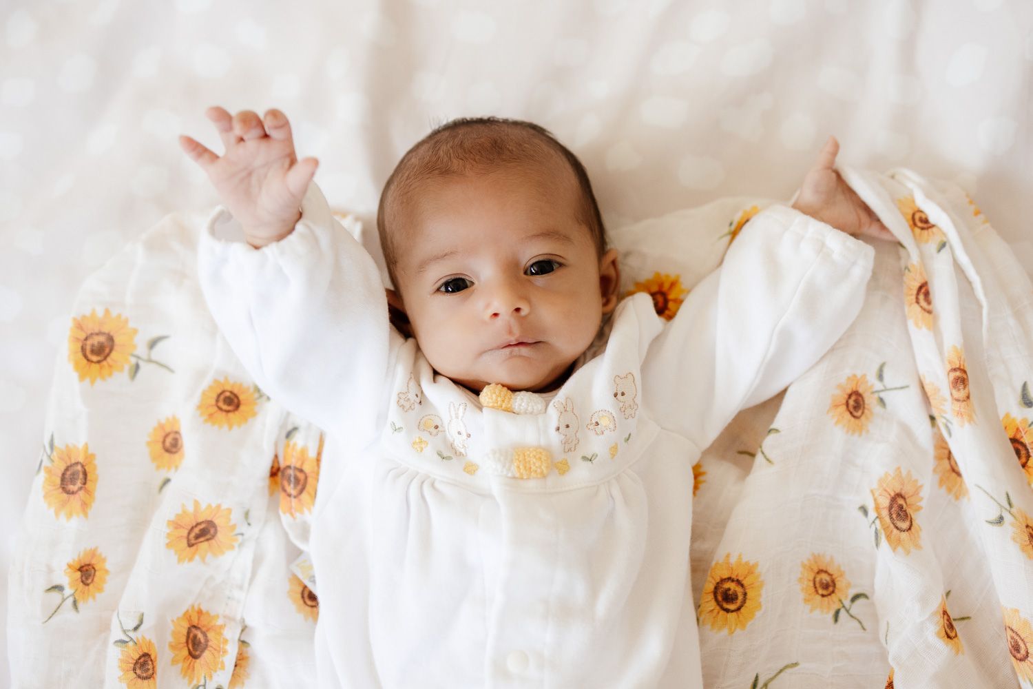 Baby stretches as she looks into the camera