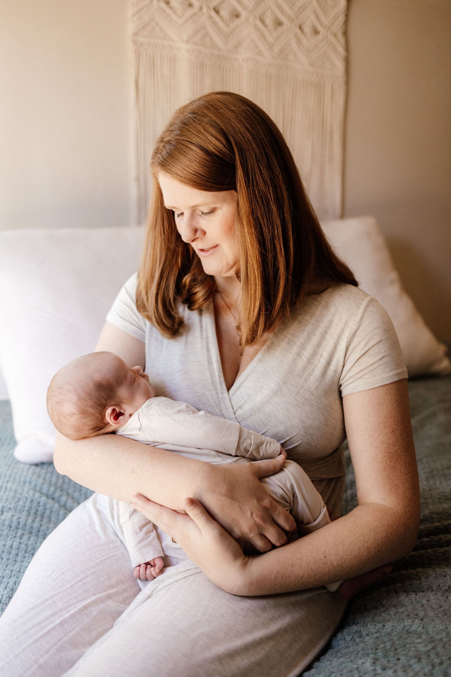 Mom smiles at her new baby at in-home newborn photo session