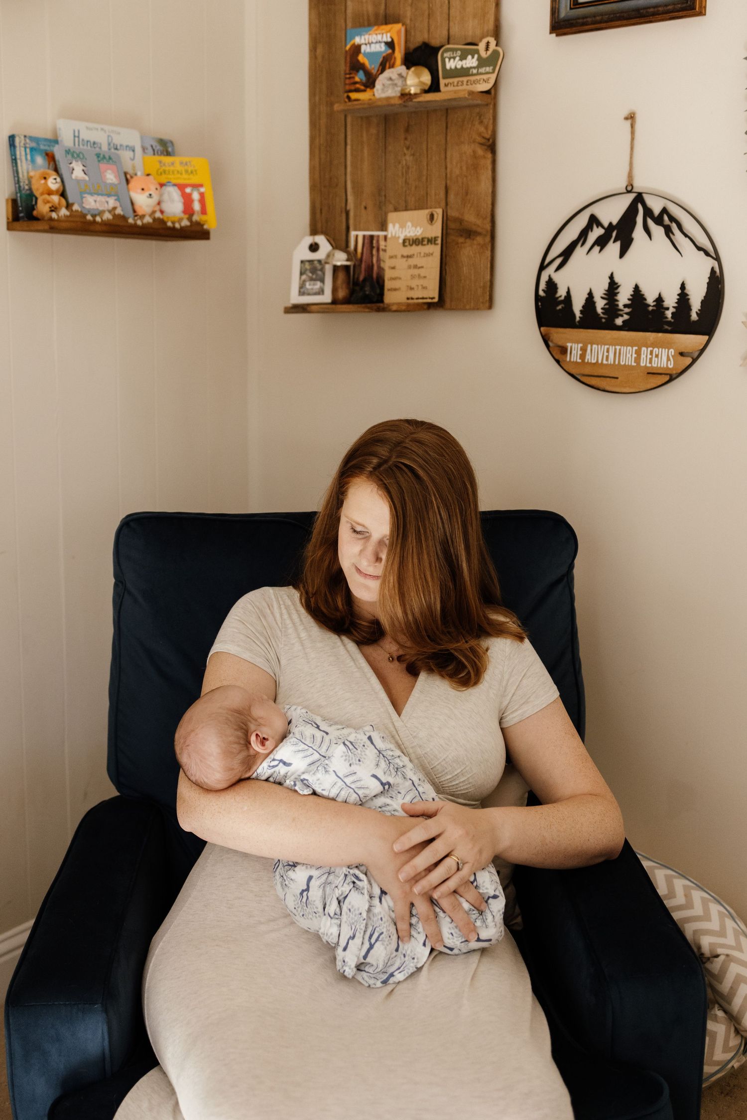 Mom cuddles baby in a rocker in her nursery during in-home lifestyle photoshoot