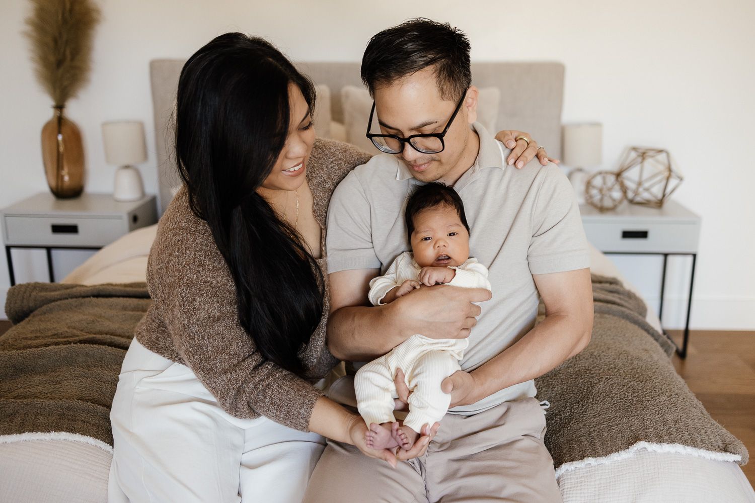 A newborn looks at the camera while being held by his parents at their in-home newborn photoshoot in Santa Clara