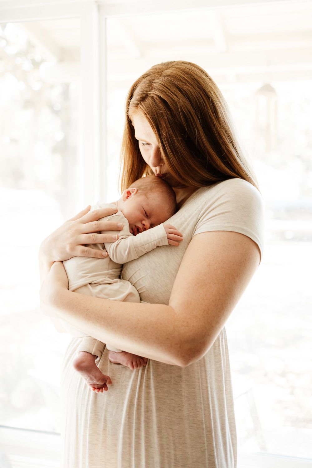 Mom holds newborn baby during Bay Area Newborn photo session with Newborn Photographer Cindy Tucey in San Jose, California