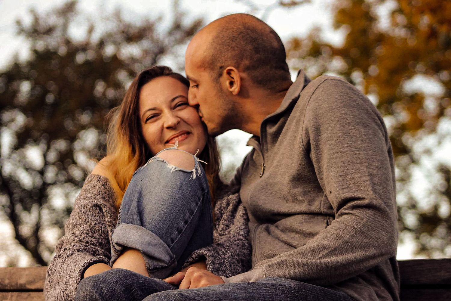 A couple shares tender moments together during a romantic outdoor photo session at sunset.