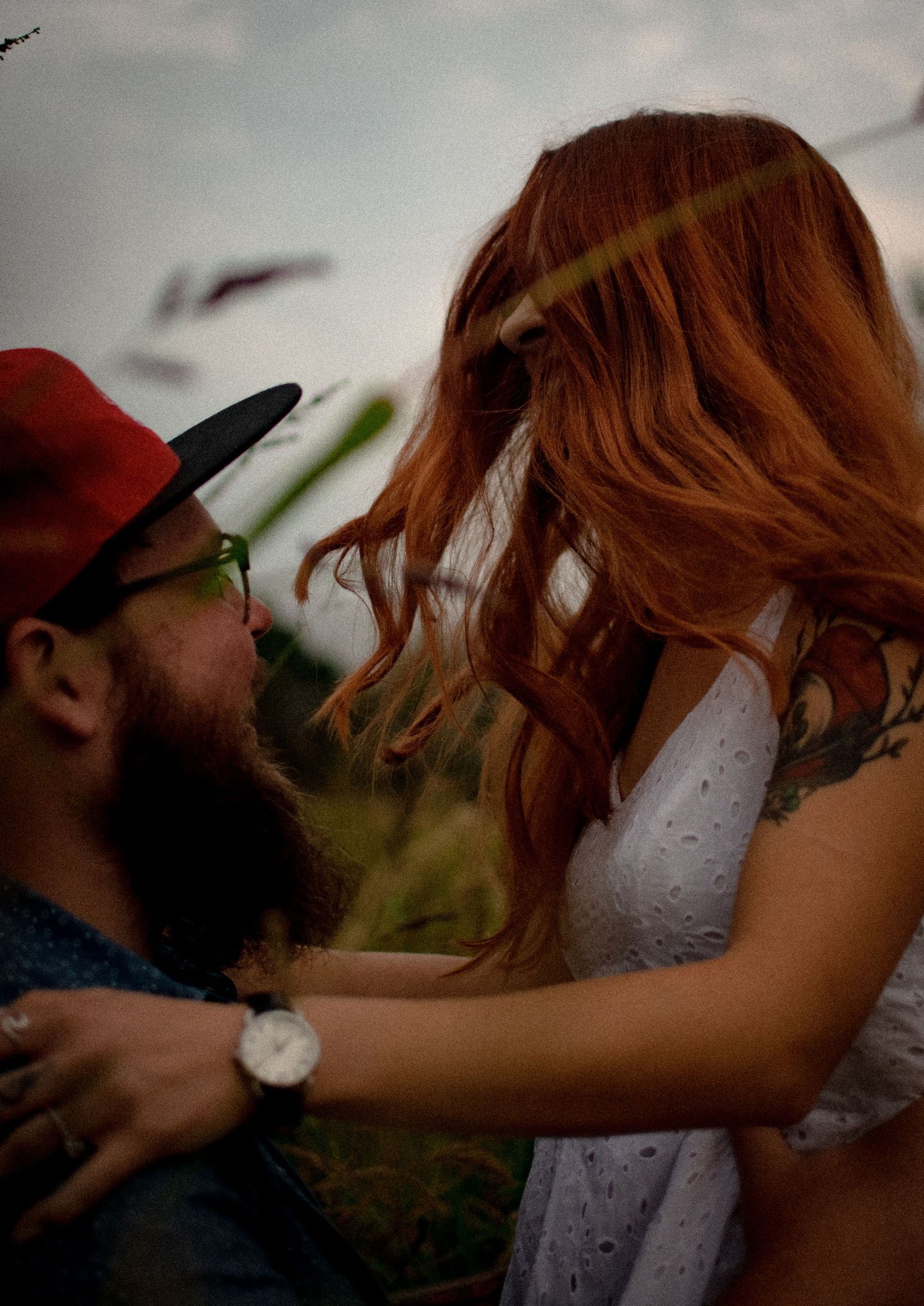 A romantic couple shares a tender kiss in a series of intimate outdoor photographs.