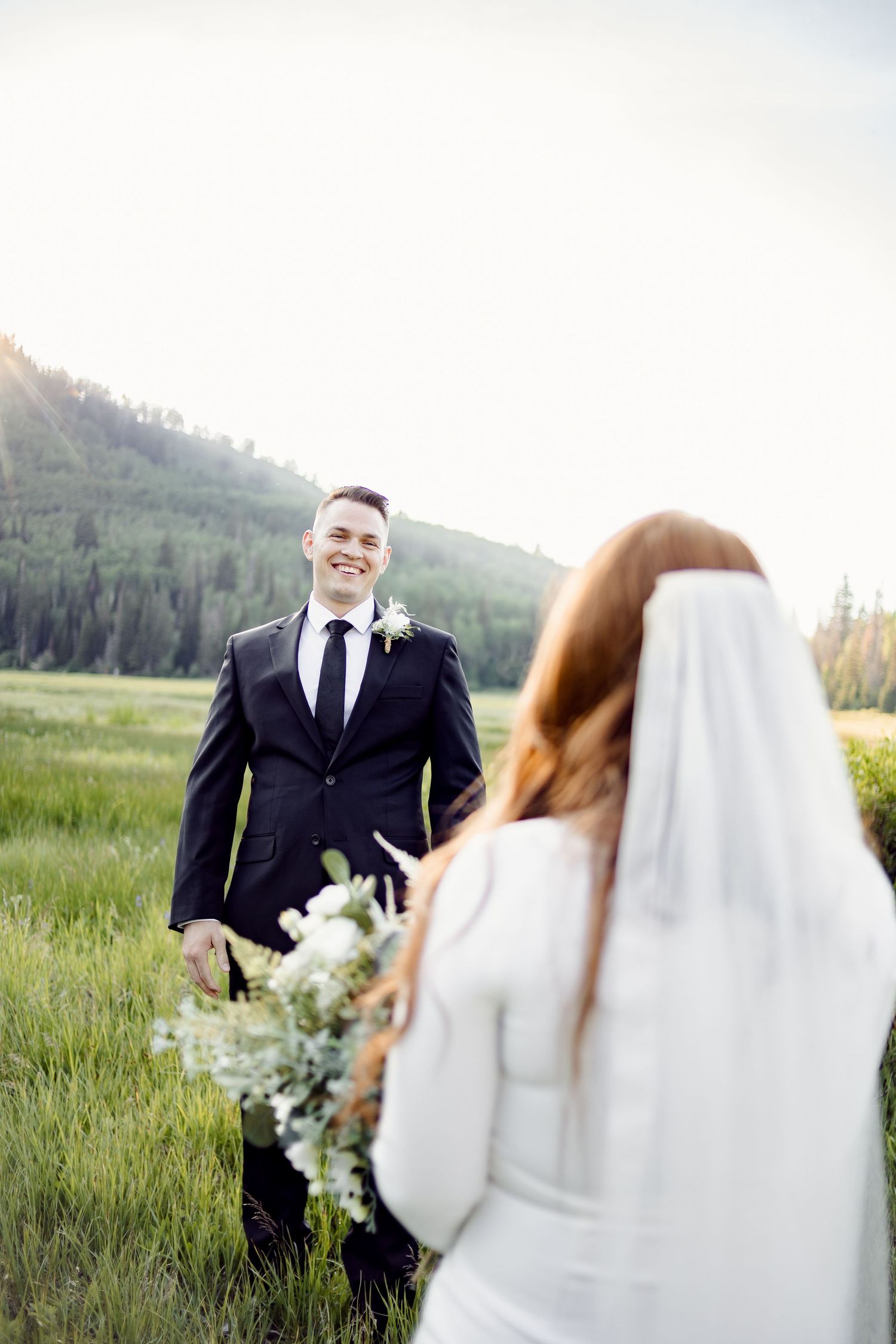 joyful groom smiling during first look before outdoor kansas city missouri wedding