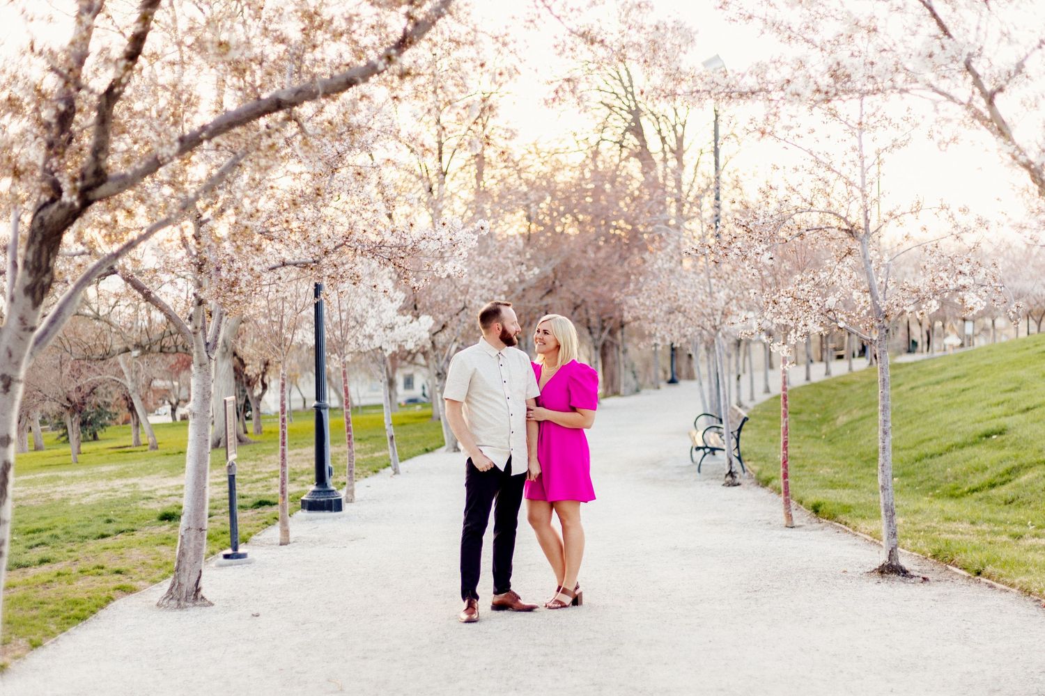 engaged missouri couple smiling among spring blossoms