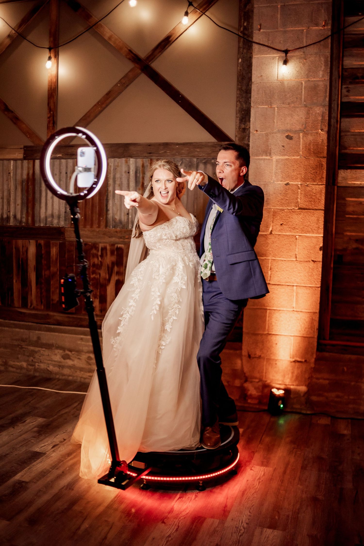 Fun bride and groom pose on a 360 video booth at their missouri wedding reception
