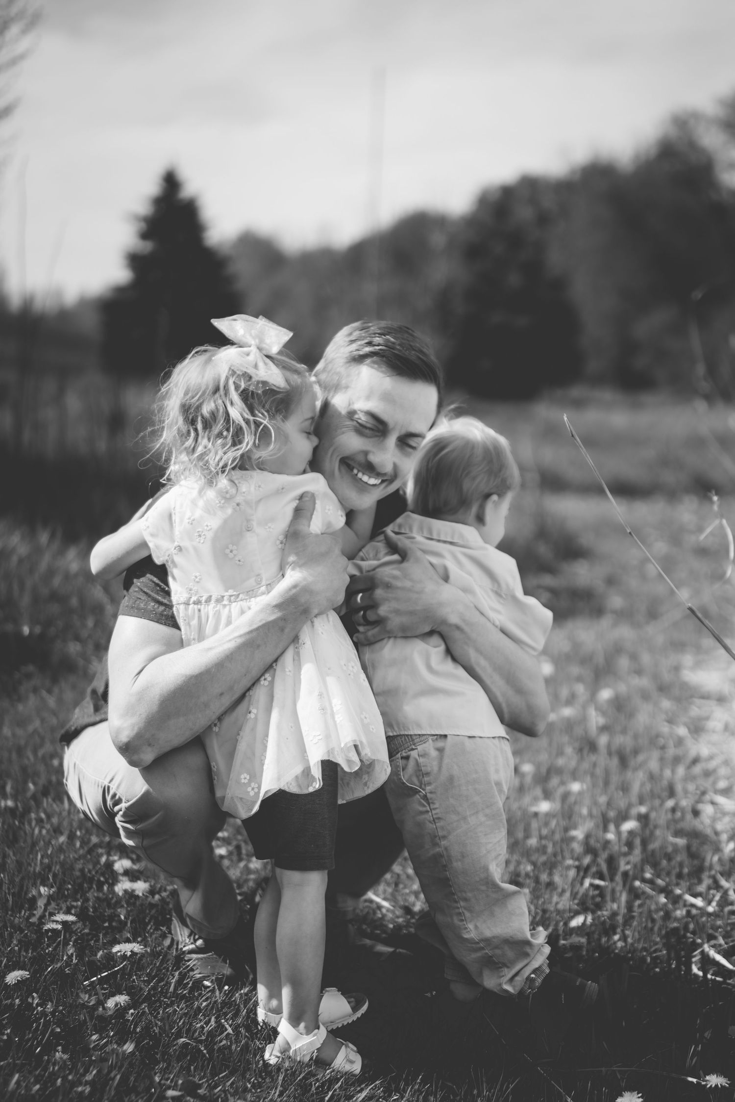 Black and white photos of tender family moments in a field of wildflowers.