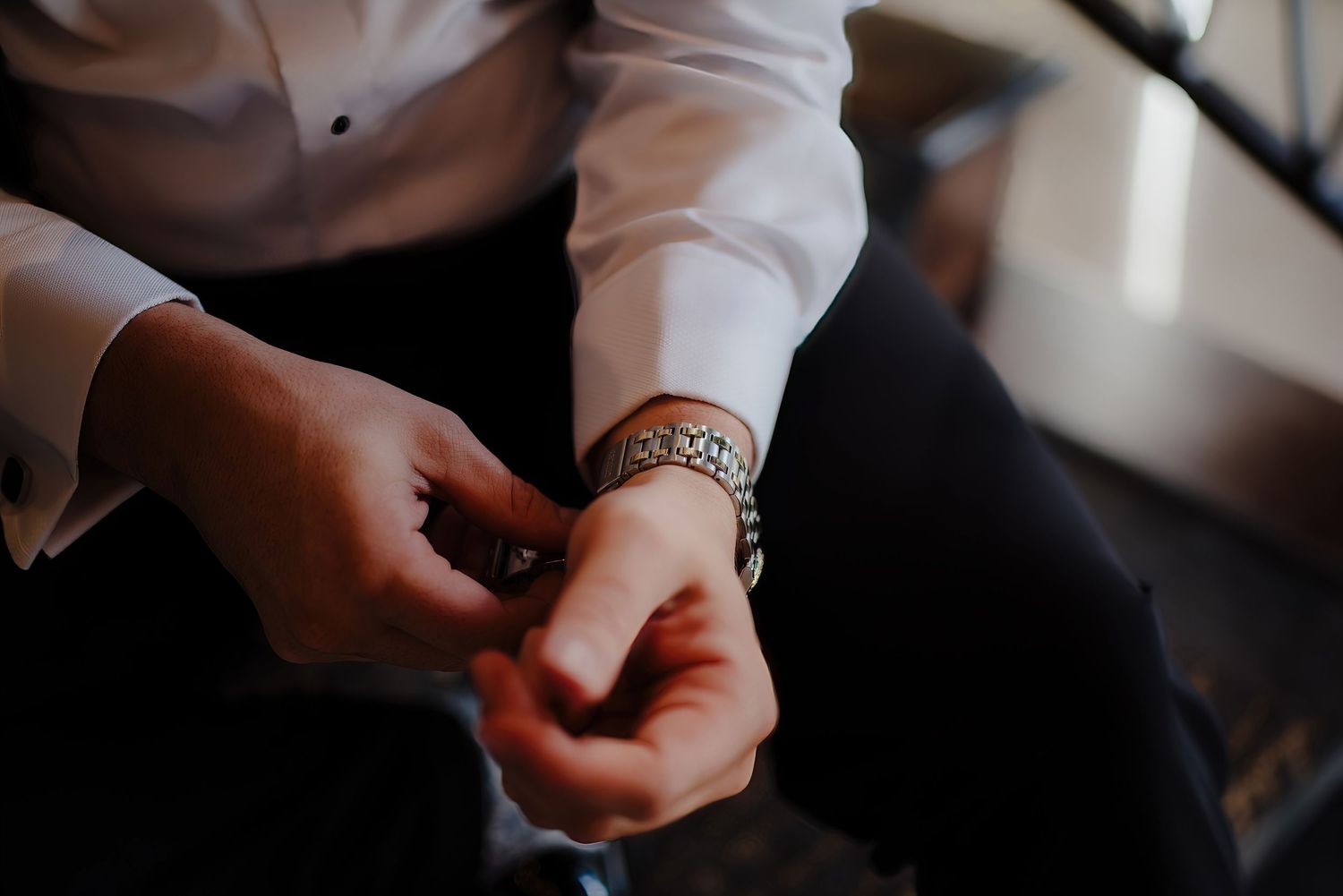 Close-up detail shot of hands with jewelry in indoor lighting.