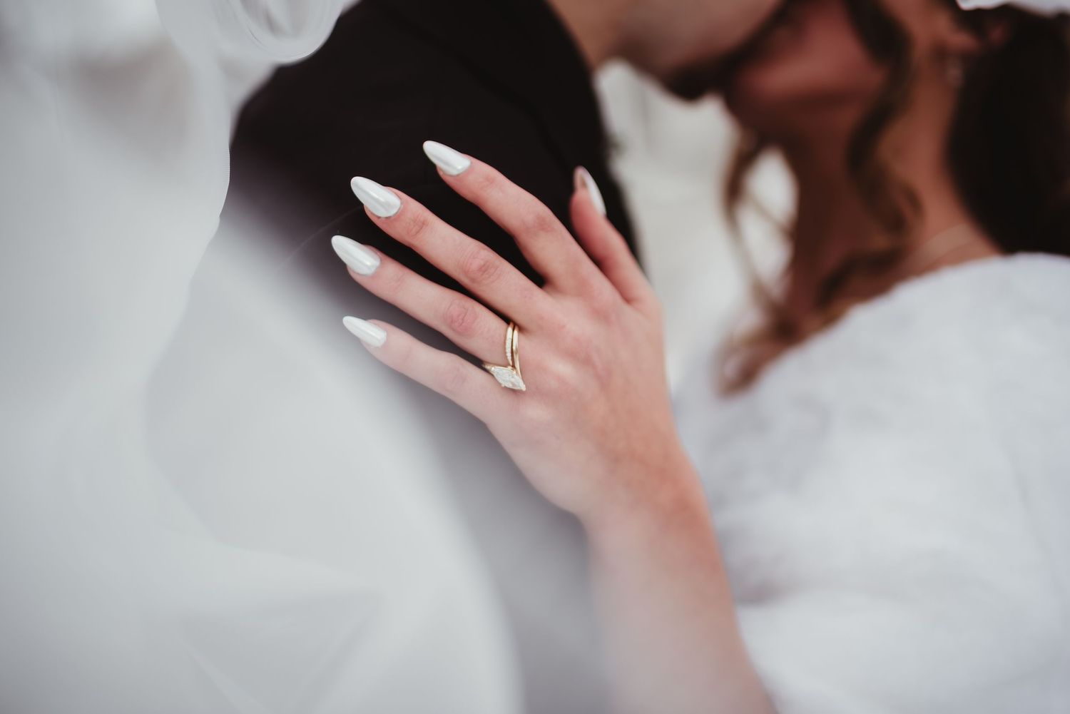 A close-up shot of hands wearing wedding rings during an intimate wedding ceremony moment.