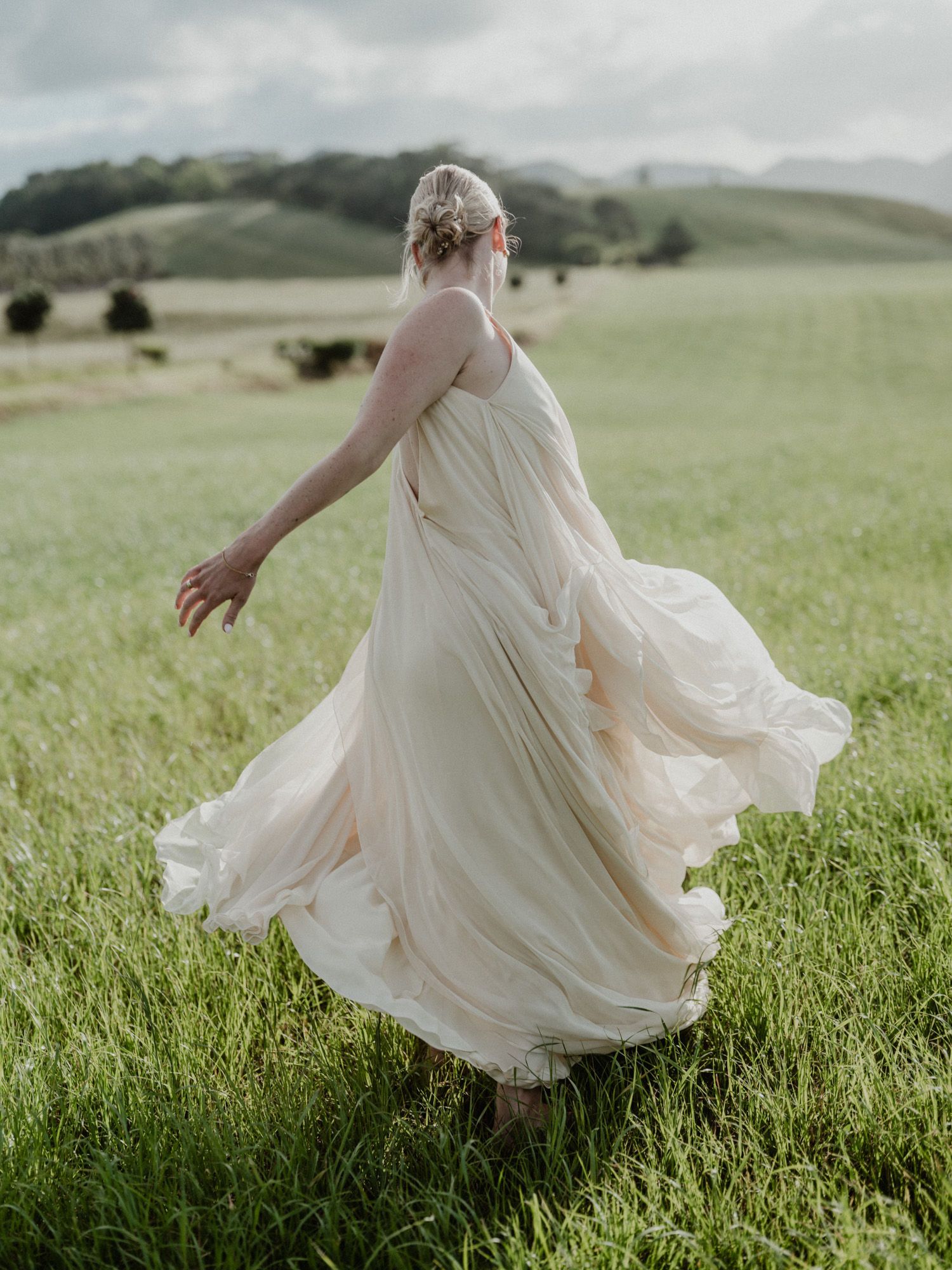 Elopement bride dancing in Portugal countryside — cinematic moment full of light, wind, and freedom