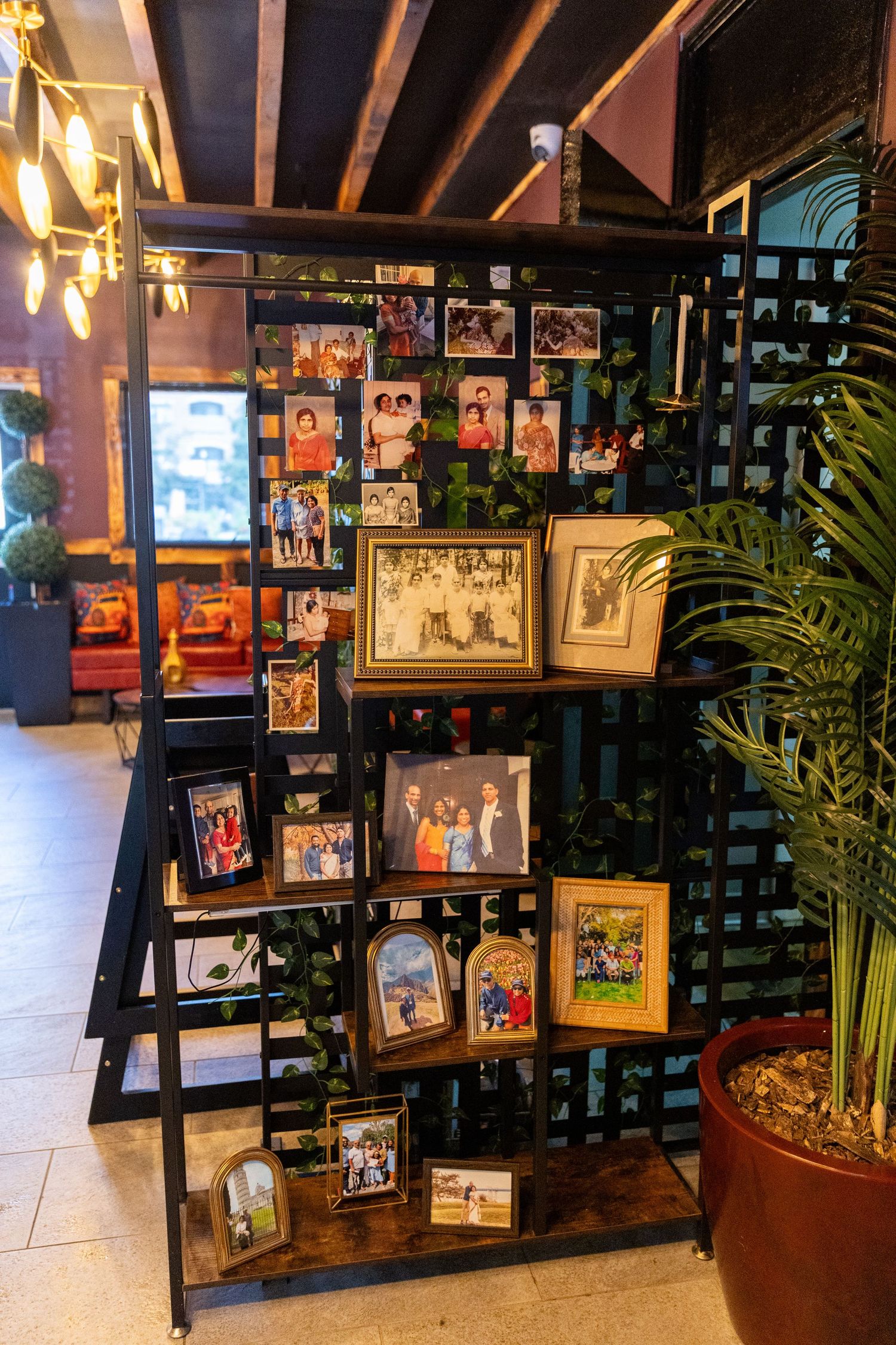 Decorative shelf display of family photos and framed pictures at a 75th birthday party venue.