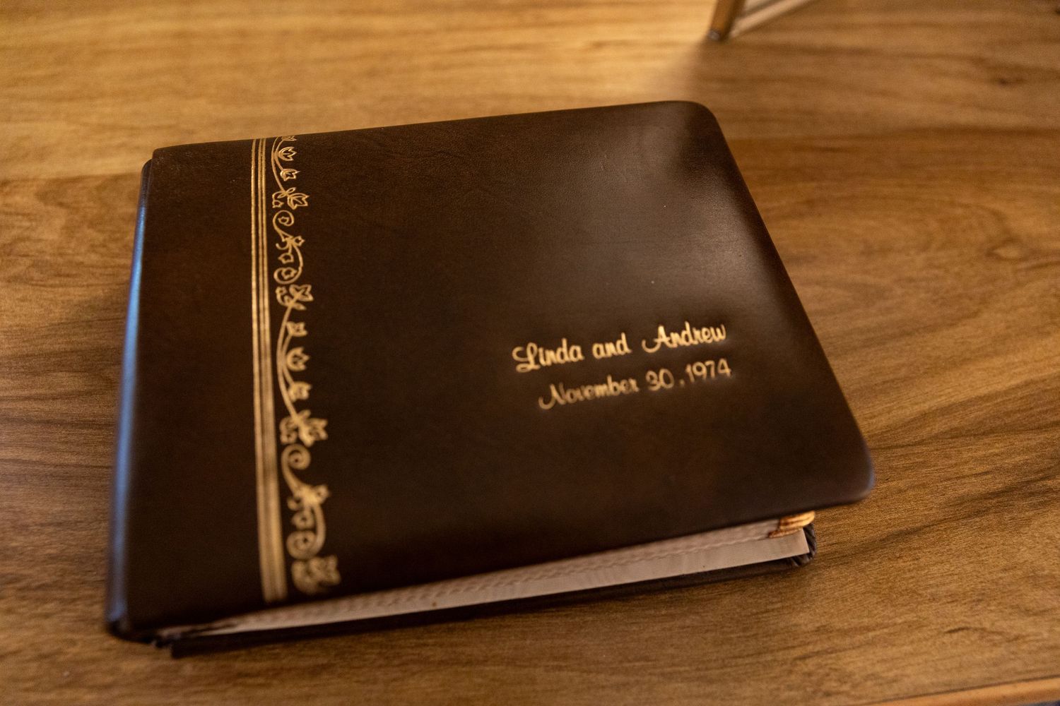 Dark leather photo album engraved with names Linda and Andrew and date November 30, 1974.