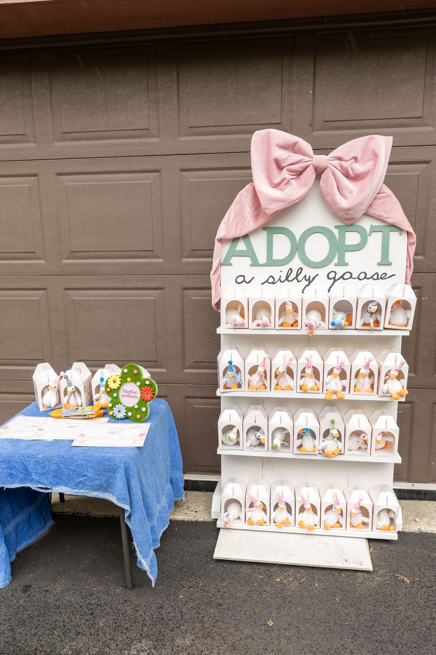 Decorative adopt a silly goose display rack with small packaged favors at an outdoor birthday party.