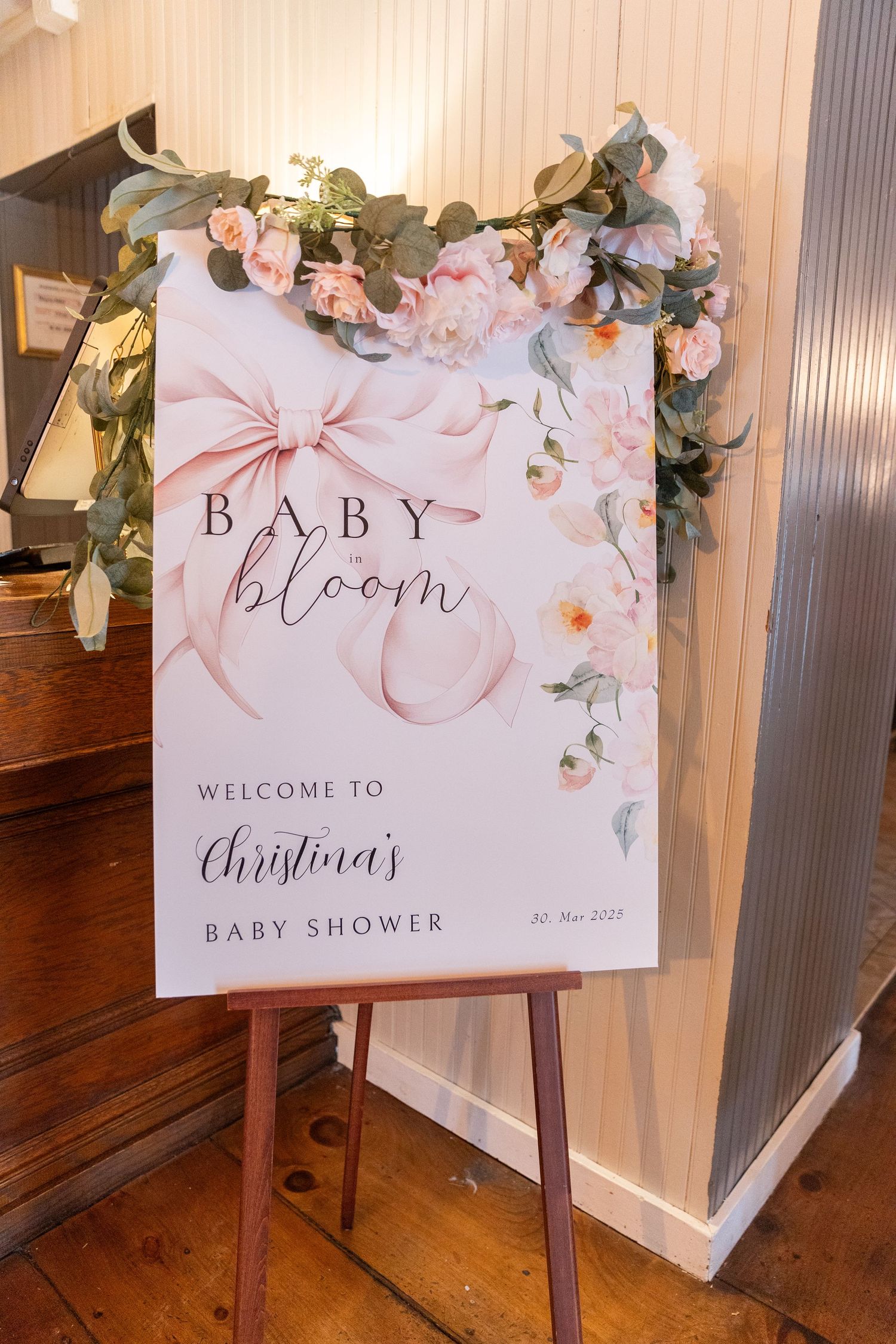 Elegant Baby in Bloom baby shower welcome sign with pink flowers on easel.