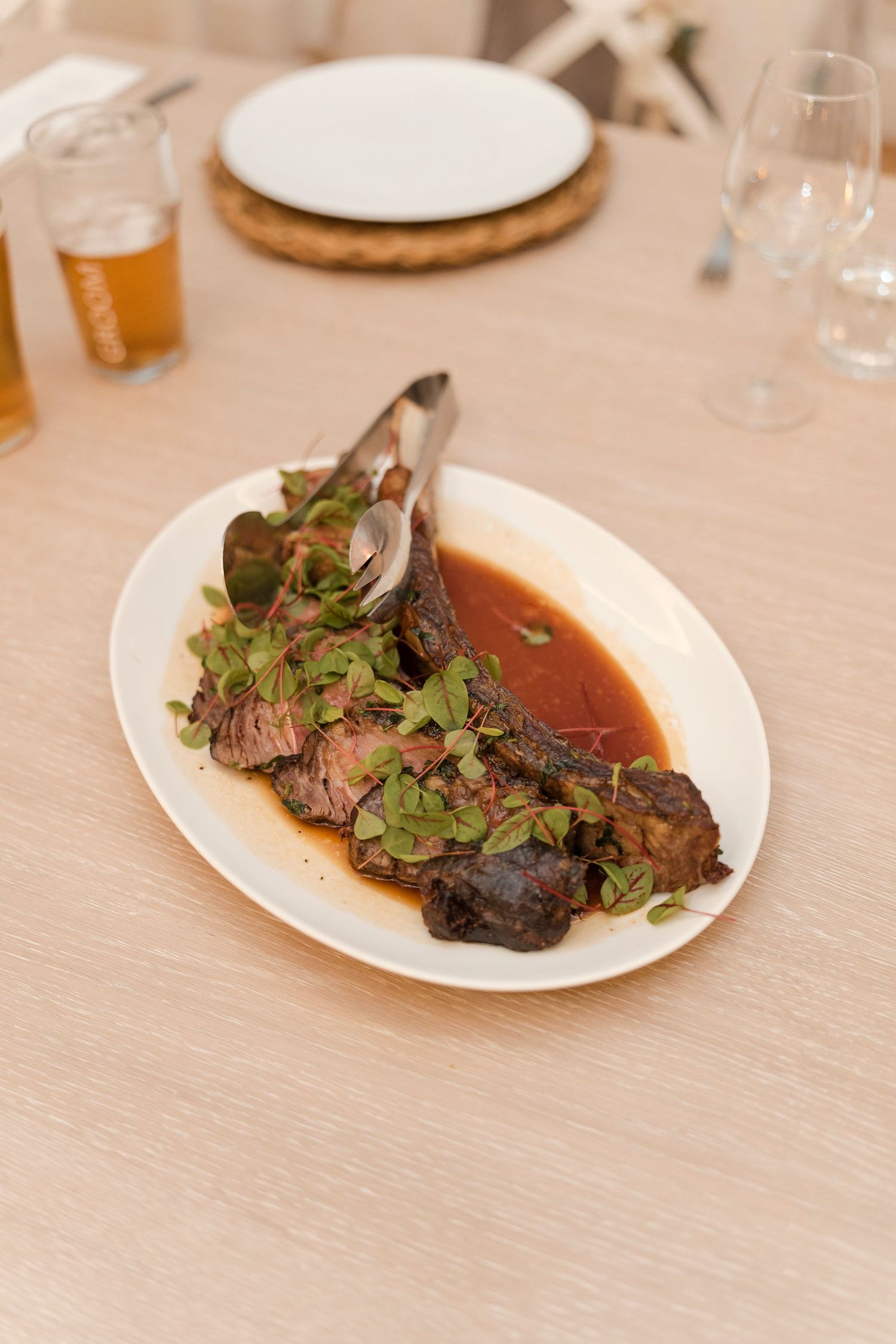 Braised meat dish garnished with fresh herbs in a rich brown sauce.