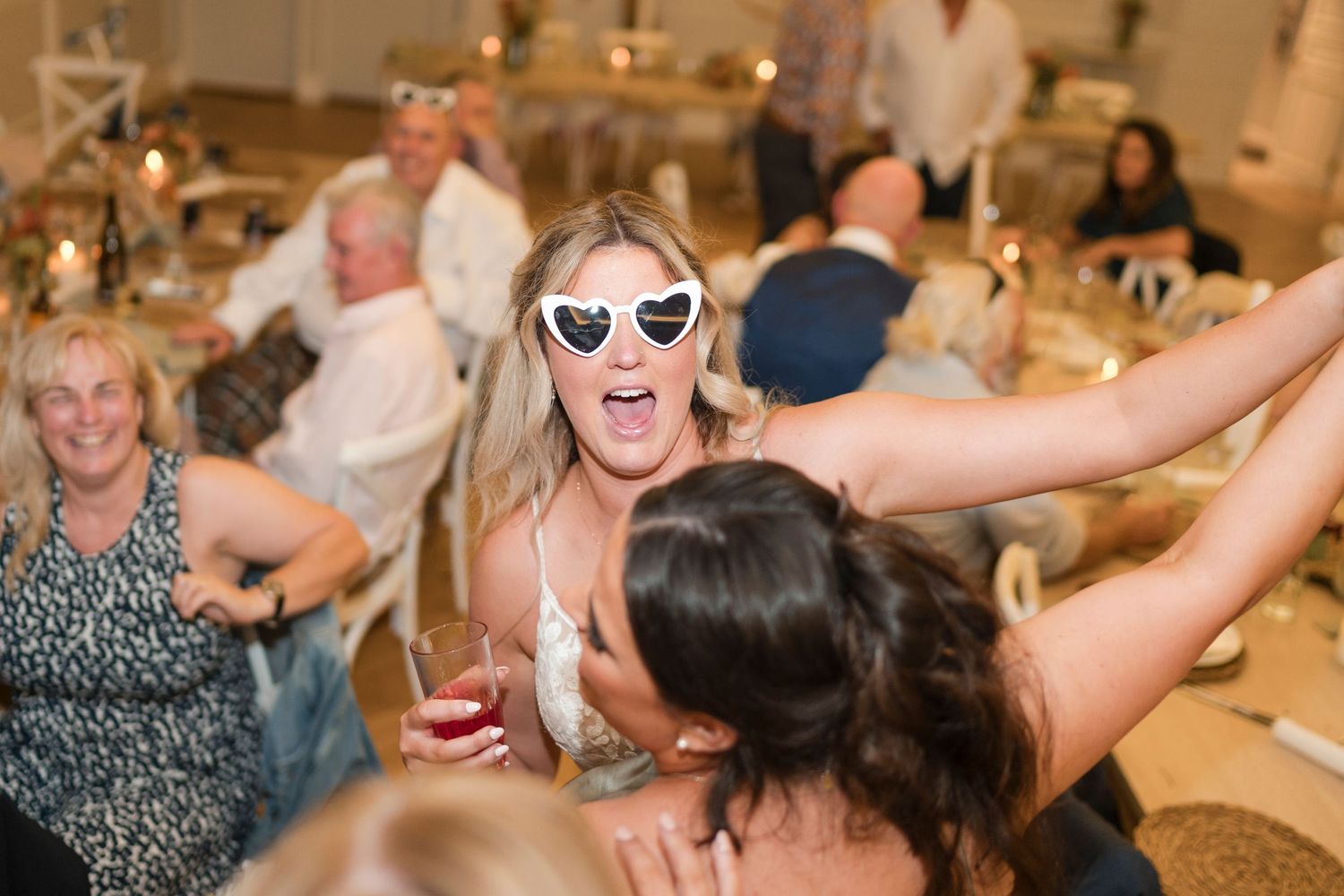 Wedding guests celebrate and dance energetically at a reception with festive party atmosphere.