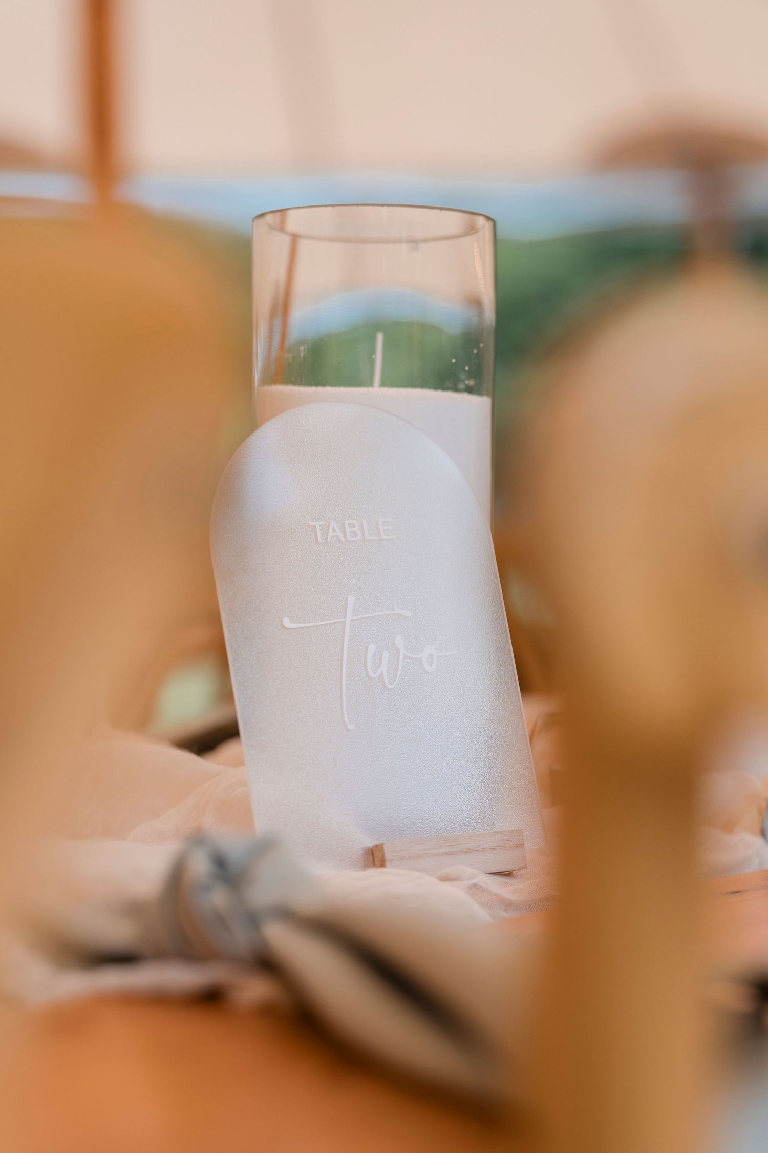 Close-up of a frosted glass table number holder with soft focus background.