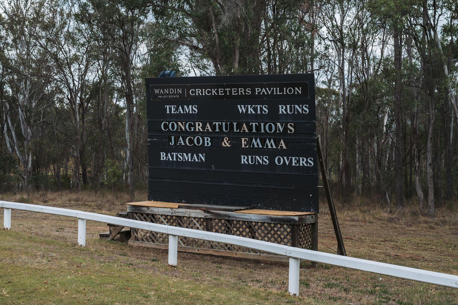 A black sign board with white text displaying wine run details at a vineyard.
