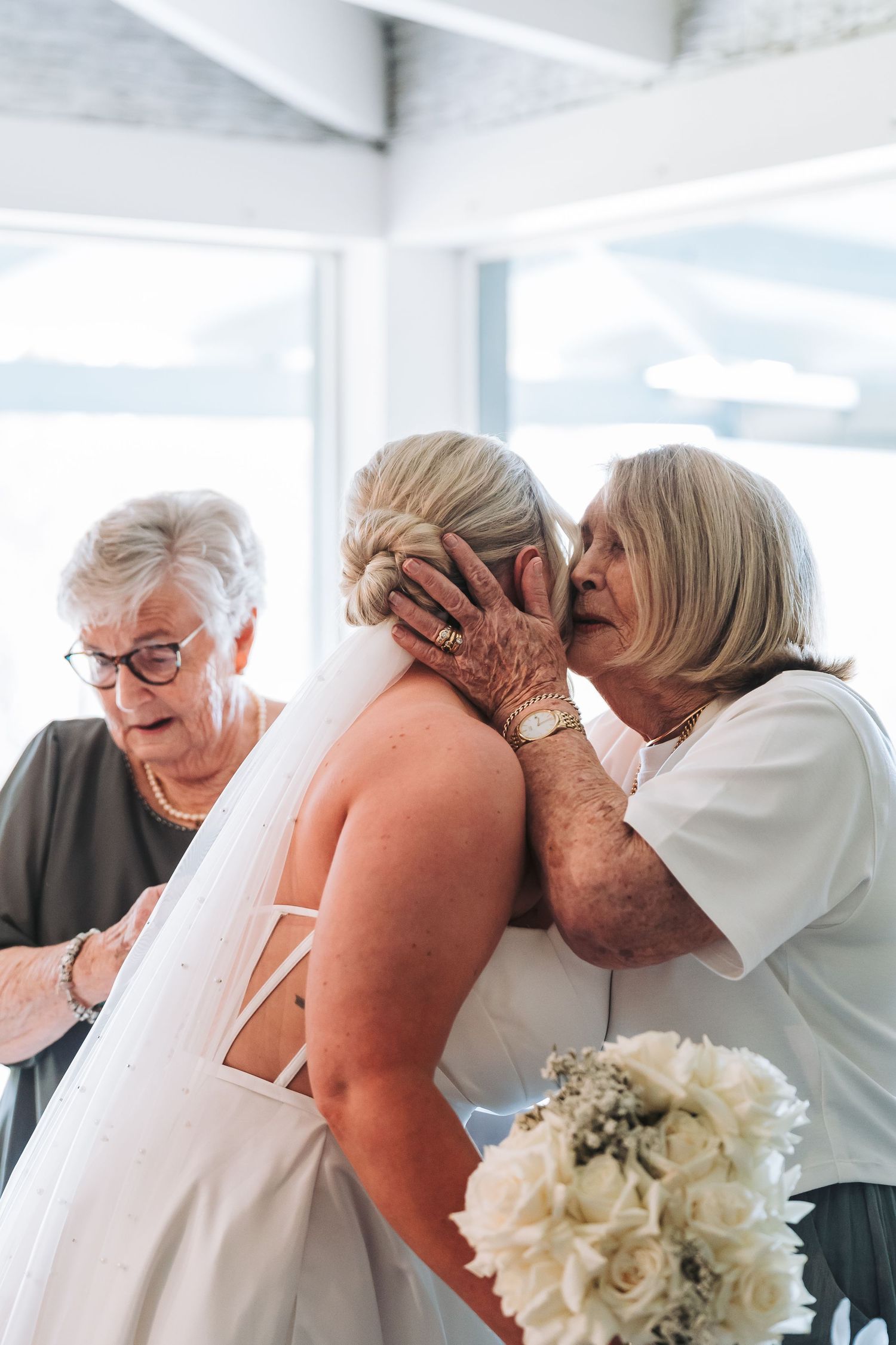 Emotional moment with a bride and family members during wedding preparations.