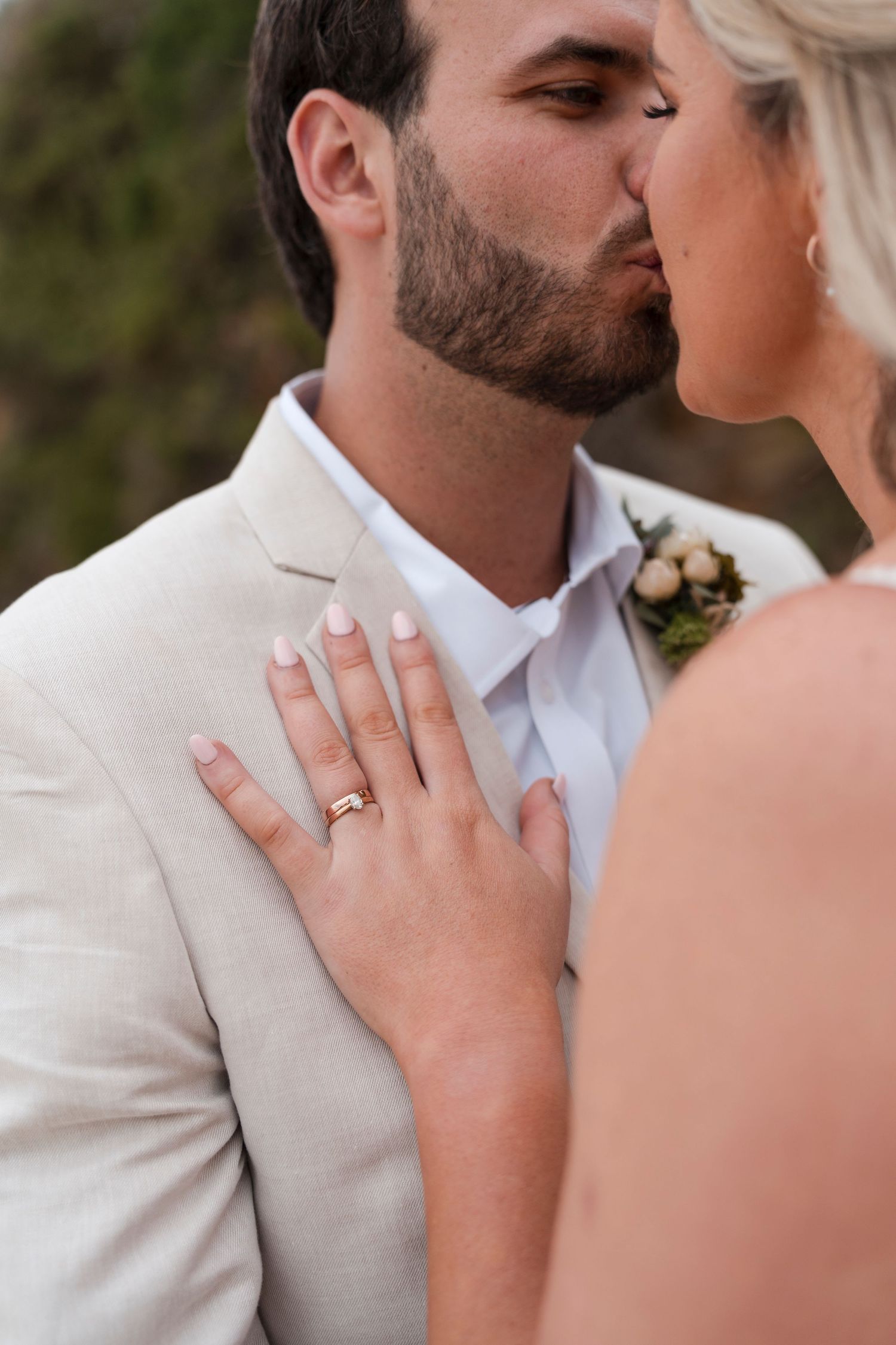Close up of wedding ring display with gentle romantic embrace.