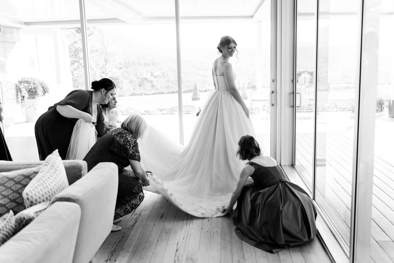 Wedding dress preparation scene in bright modern room with mountain views.