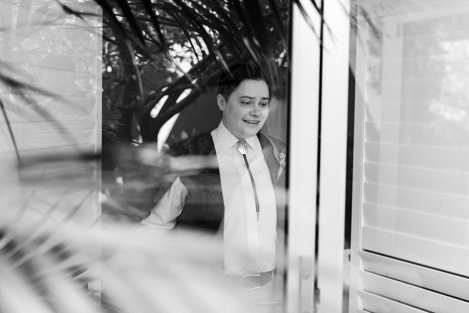 Black and white candid moment through window reflections.