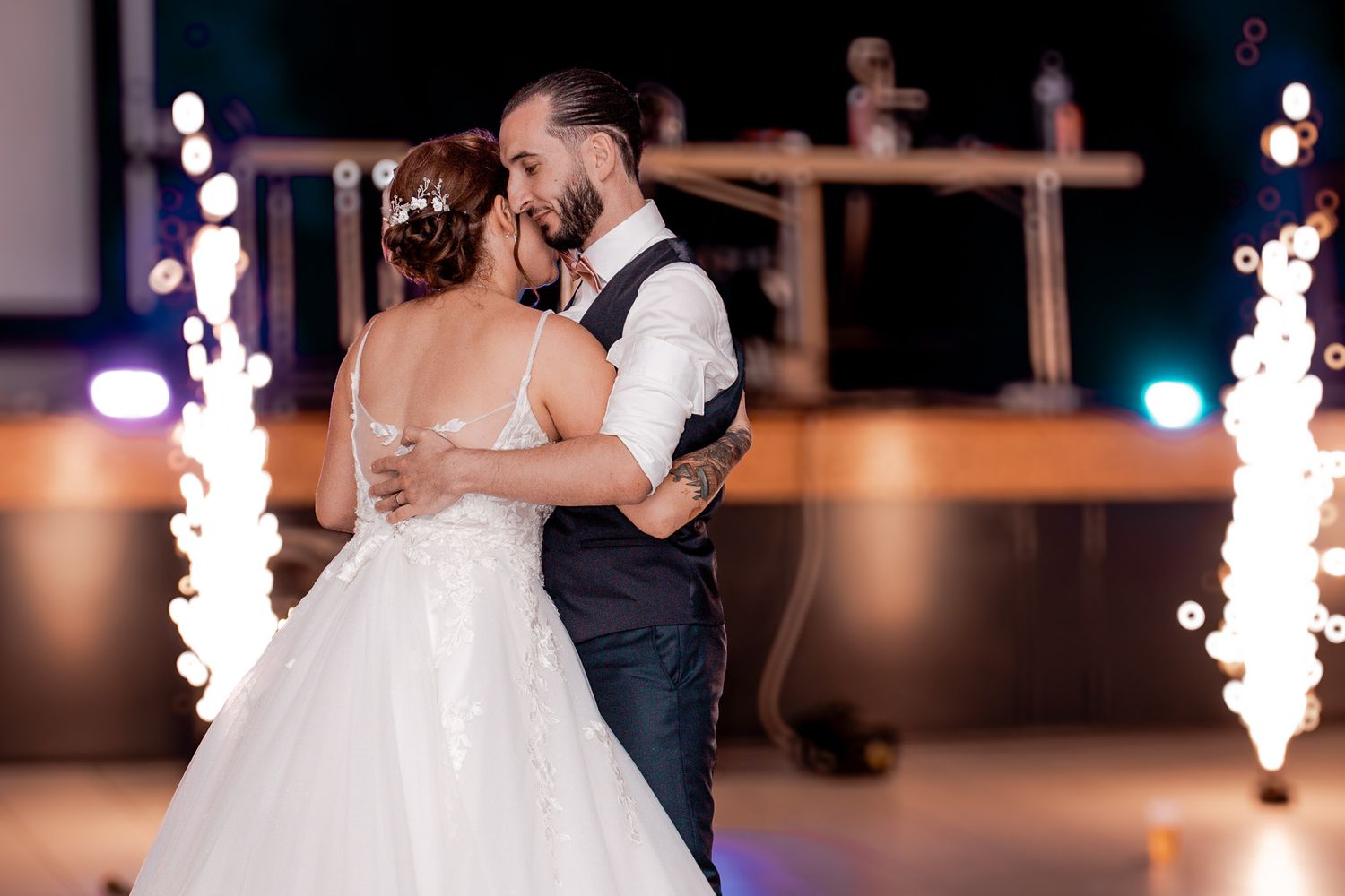 Newlyweds share their first dance surrounded by sparkling fountain fireworks at their wedding reception.