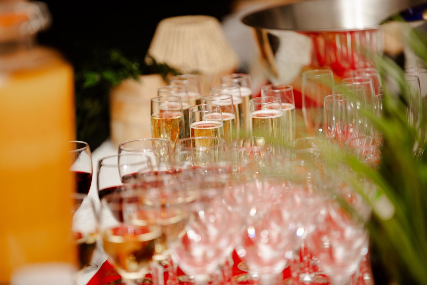 Elegant rows of champagne and wine glasses arranged on a table at a formal catered event.